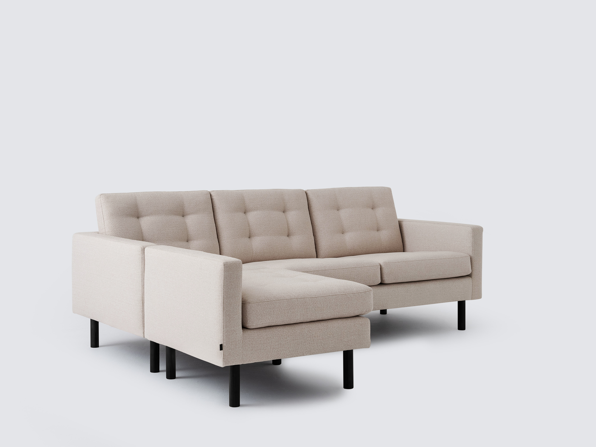 Angled view of the Joan left hand sectional upholstered in beige fabric