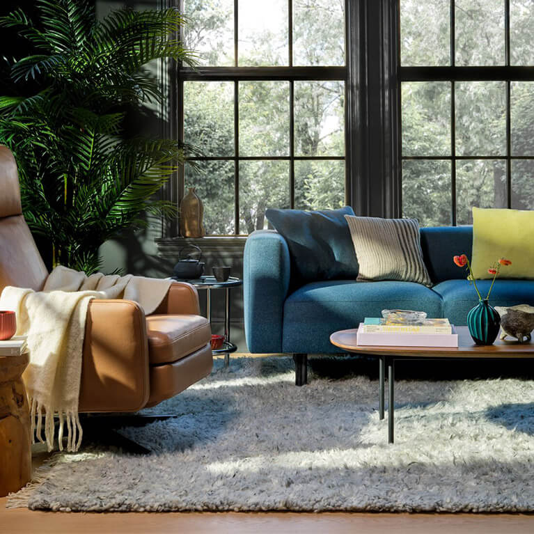 Large blue fabric EQ3 sofa is displayed in living room setting. Link to sofas category