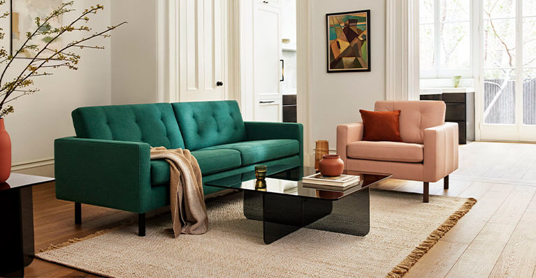 Green sofa and pink chair create a living room setting. Link to seating category