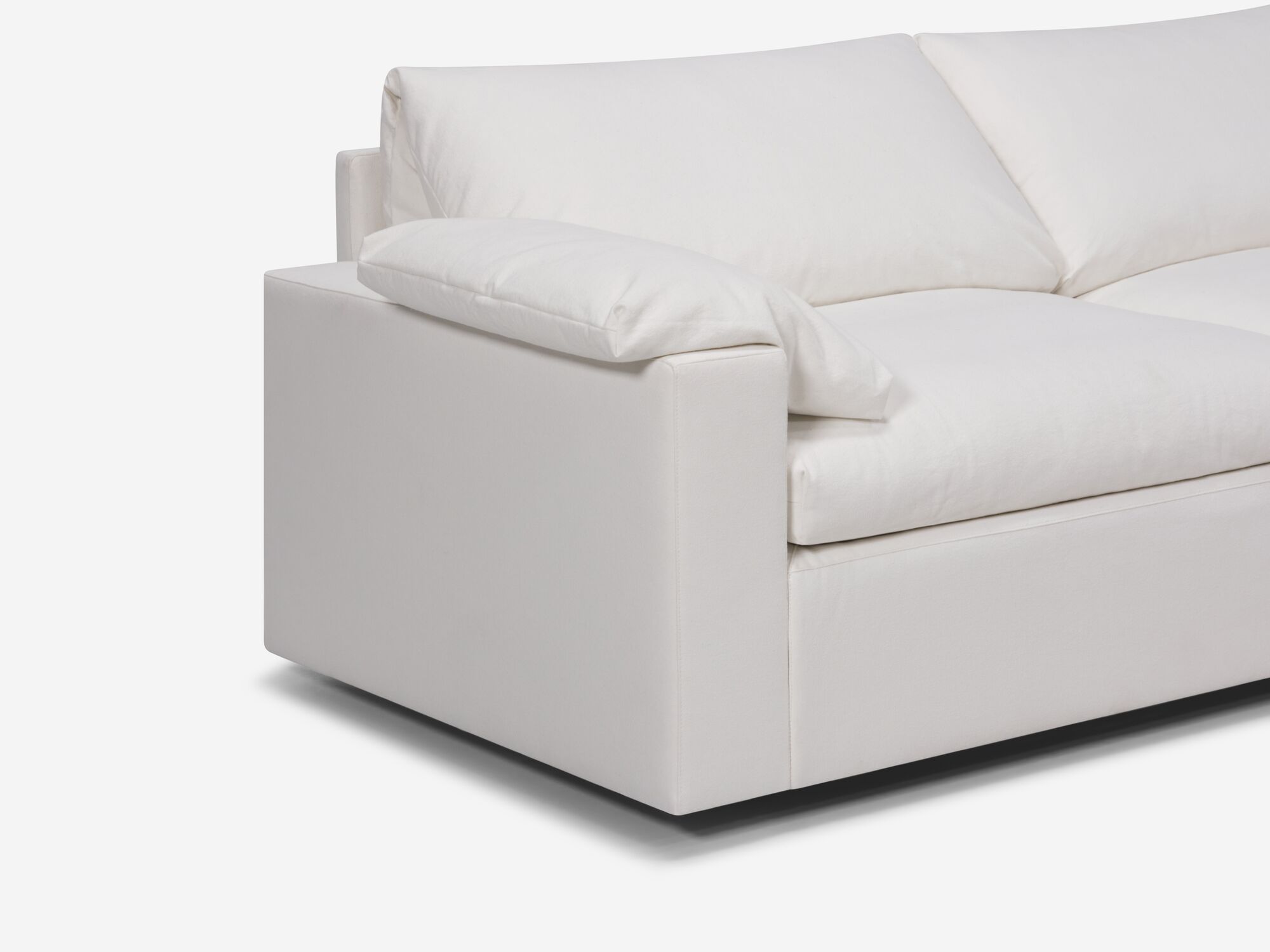 White sectional sofa with right hand chaise and pillow seat detail view