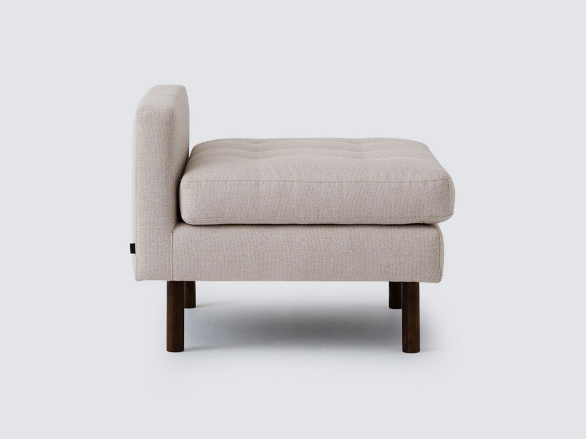 Side view of the Joan extended chair upholstered in beige fabric