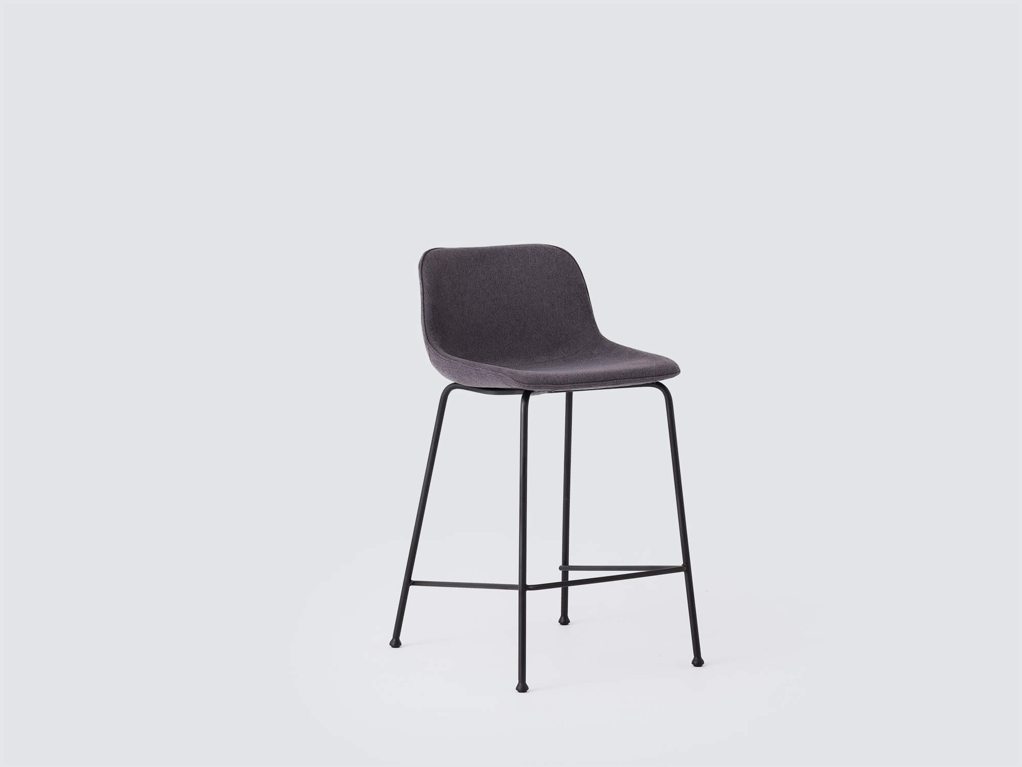 Angled view of the Oles modern bar stool with grey fabric seat