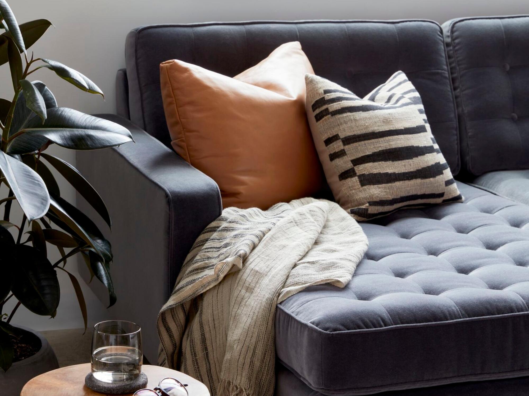 Black and beige pillow with matching throw on gray sectional