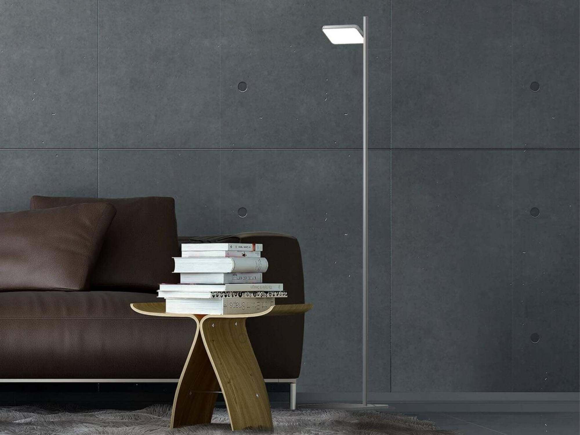 Talia modern floor lamp in white sits beside a brown leather sofa and accent table