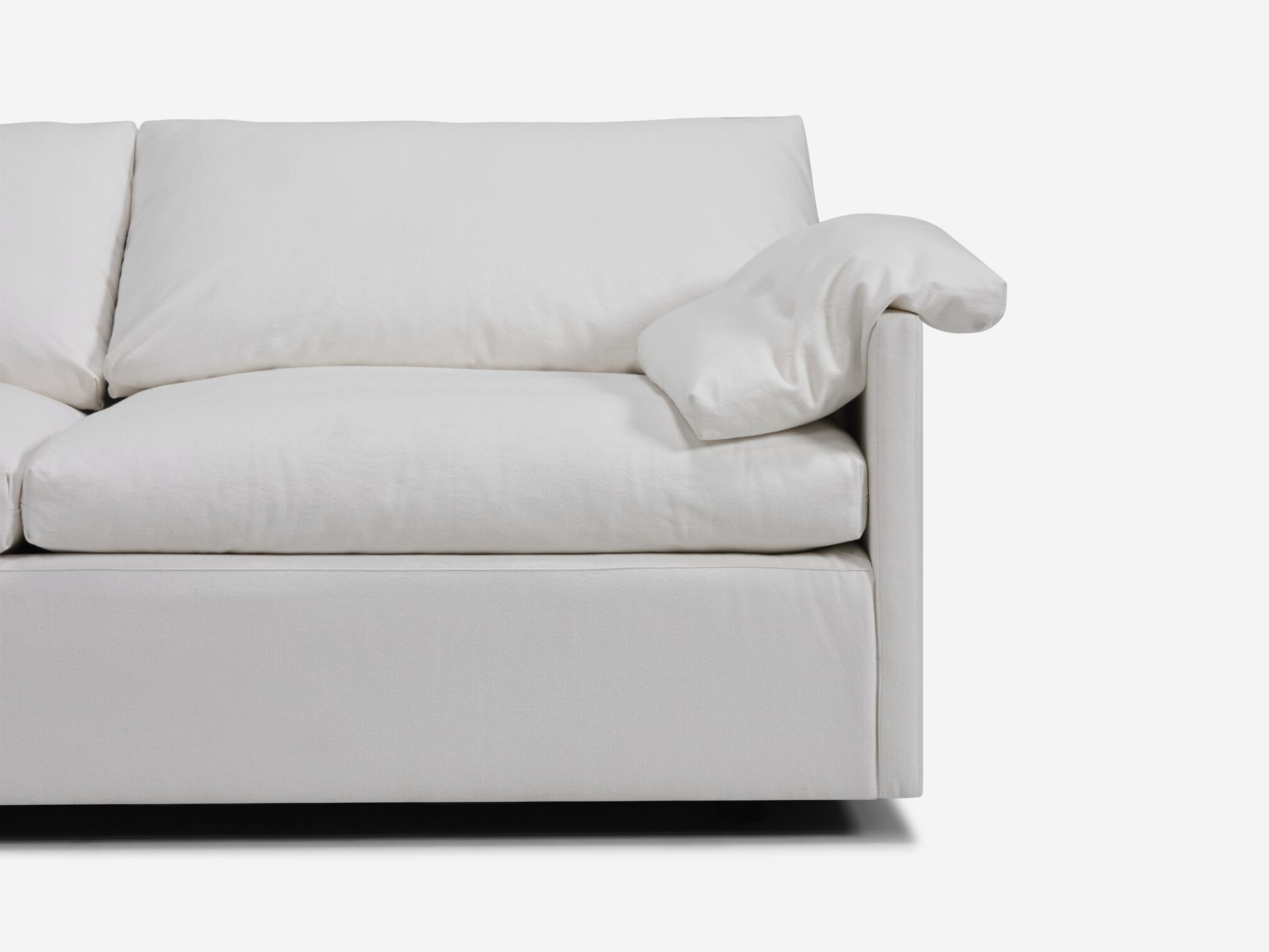 White sectional sofa with narrow arms and pillow seat detail view