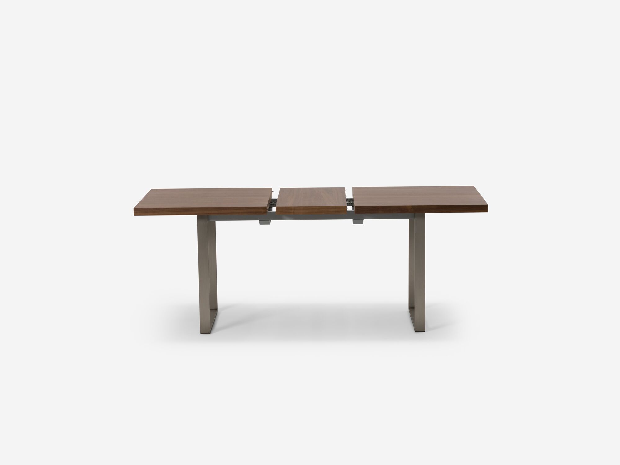 Expandable dining table with stainless steel legs and walnut top with one leaf separated side view