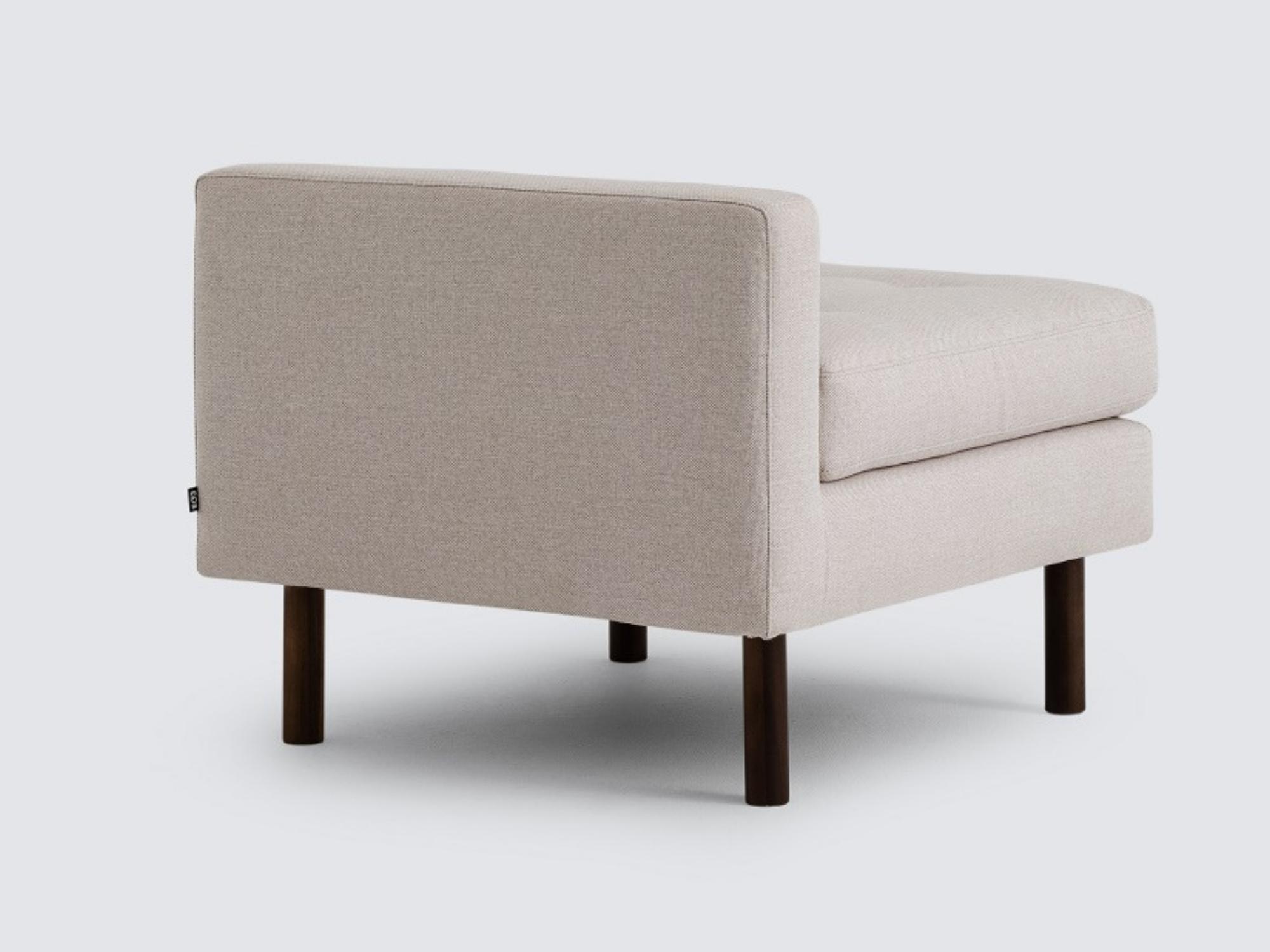 Back angled view of the Joan extended chair upholstered in beige fabric