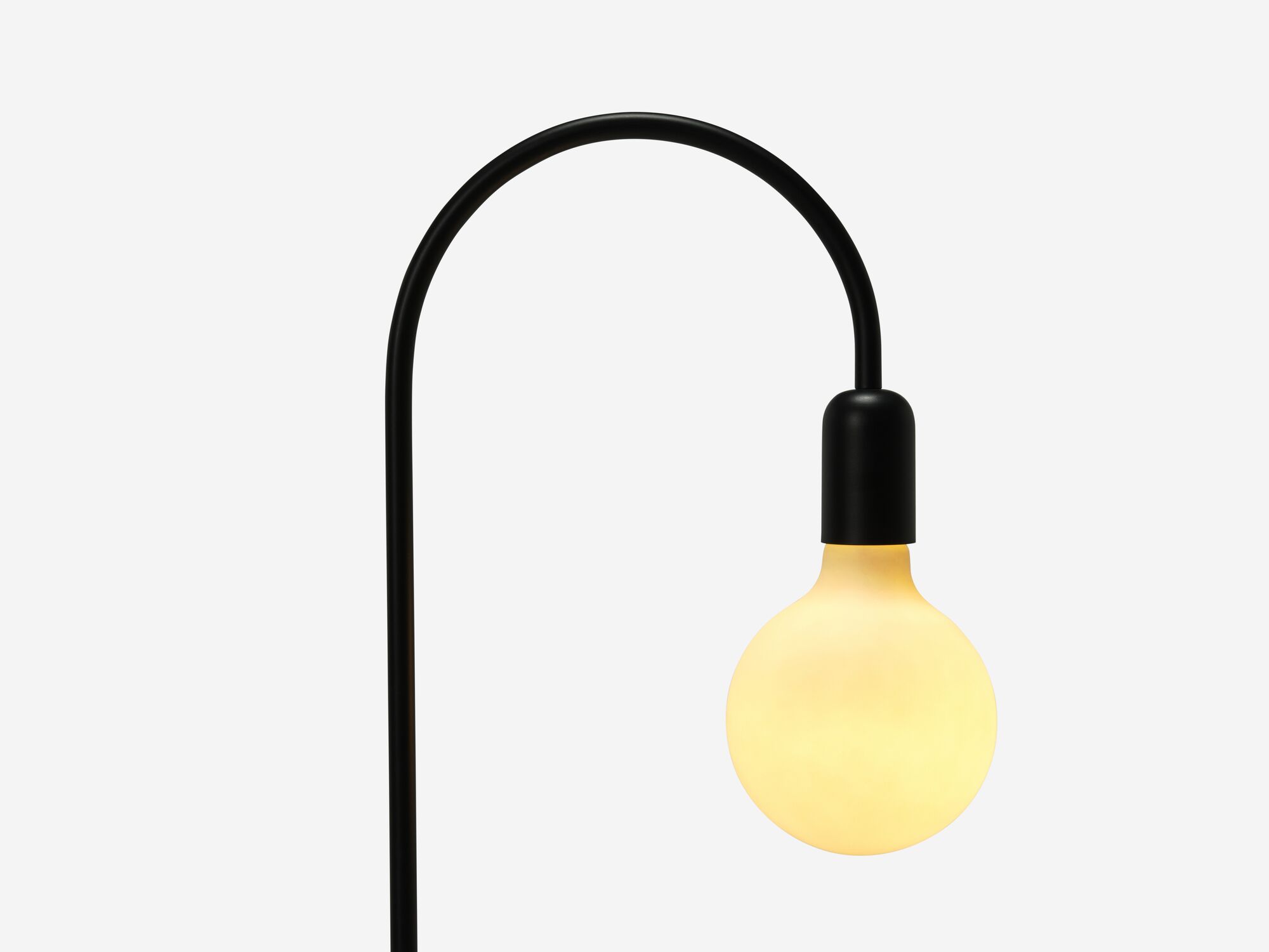 Black arched floor lamp with light on detail bulb view
