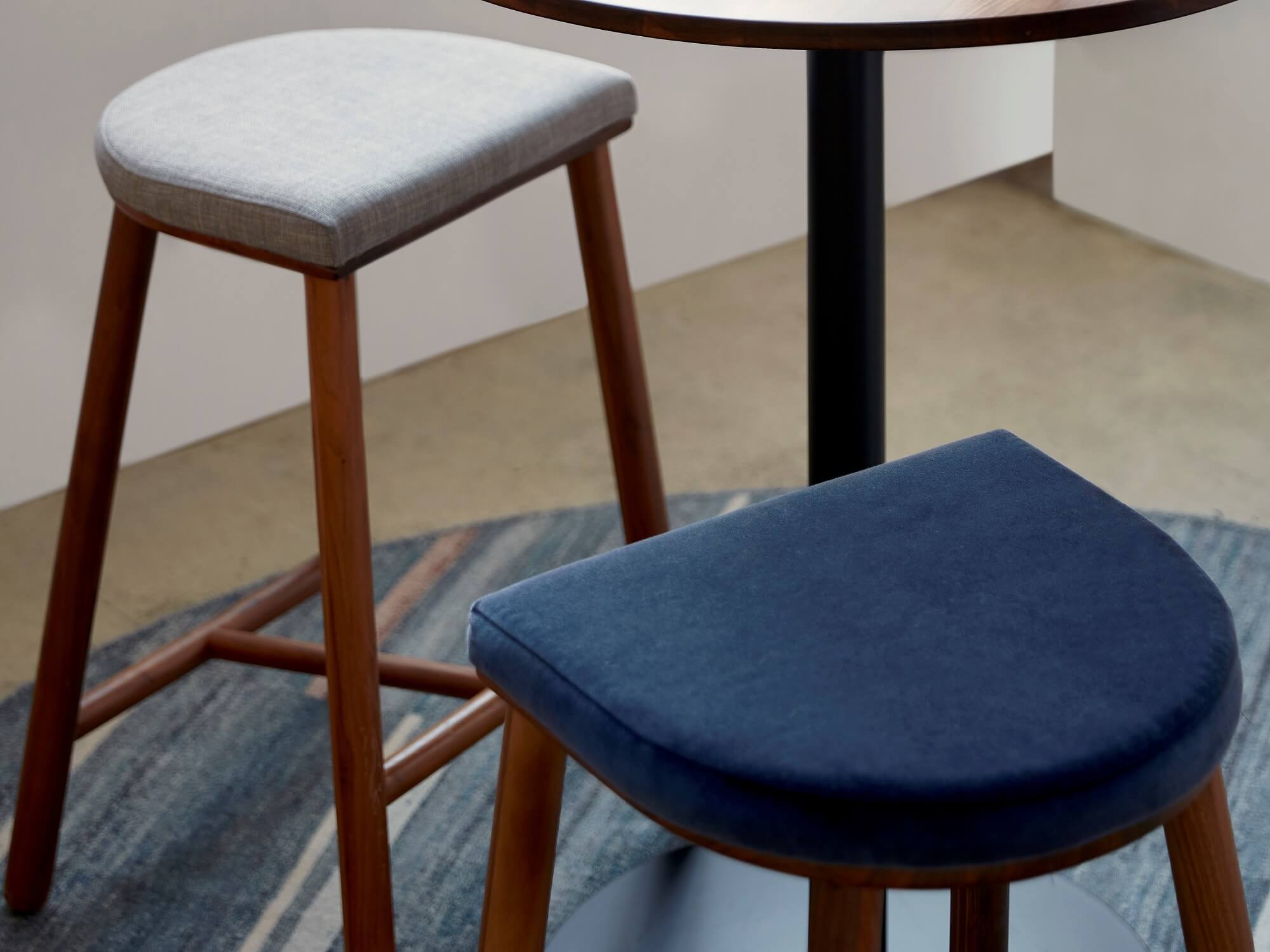 Beige and blue fabric counter stools around tall round table