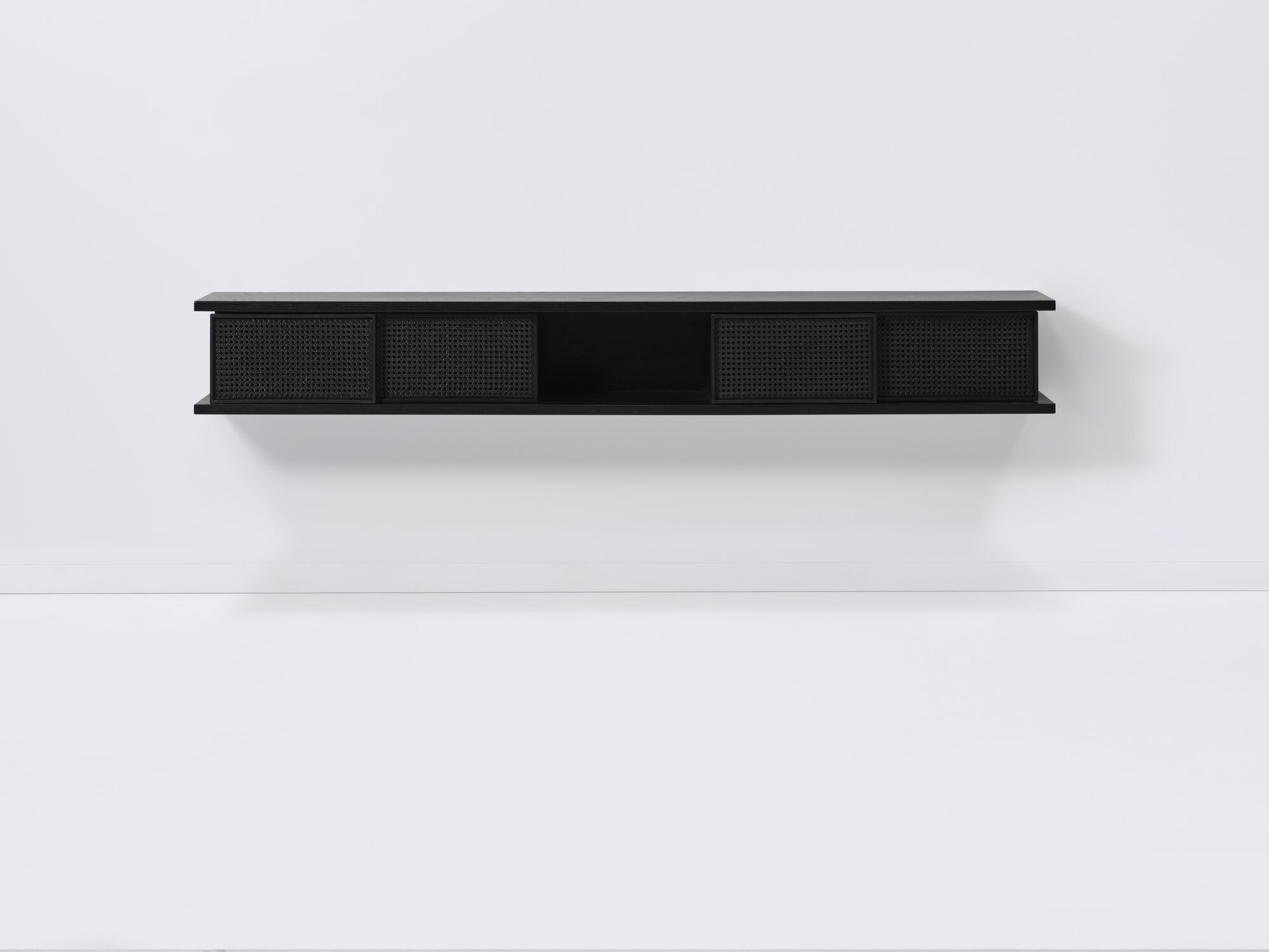 Front view of long black floating shelf with black cane doors