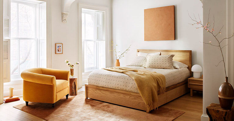 Oak storage bed is displayed in a brightly lit bedroom. Link to bedroom category