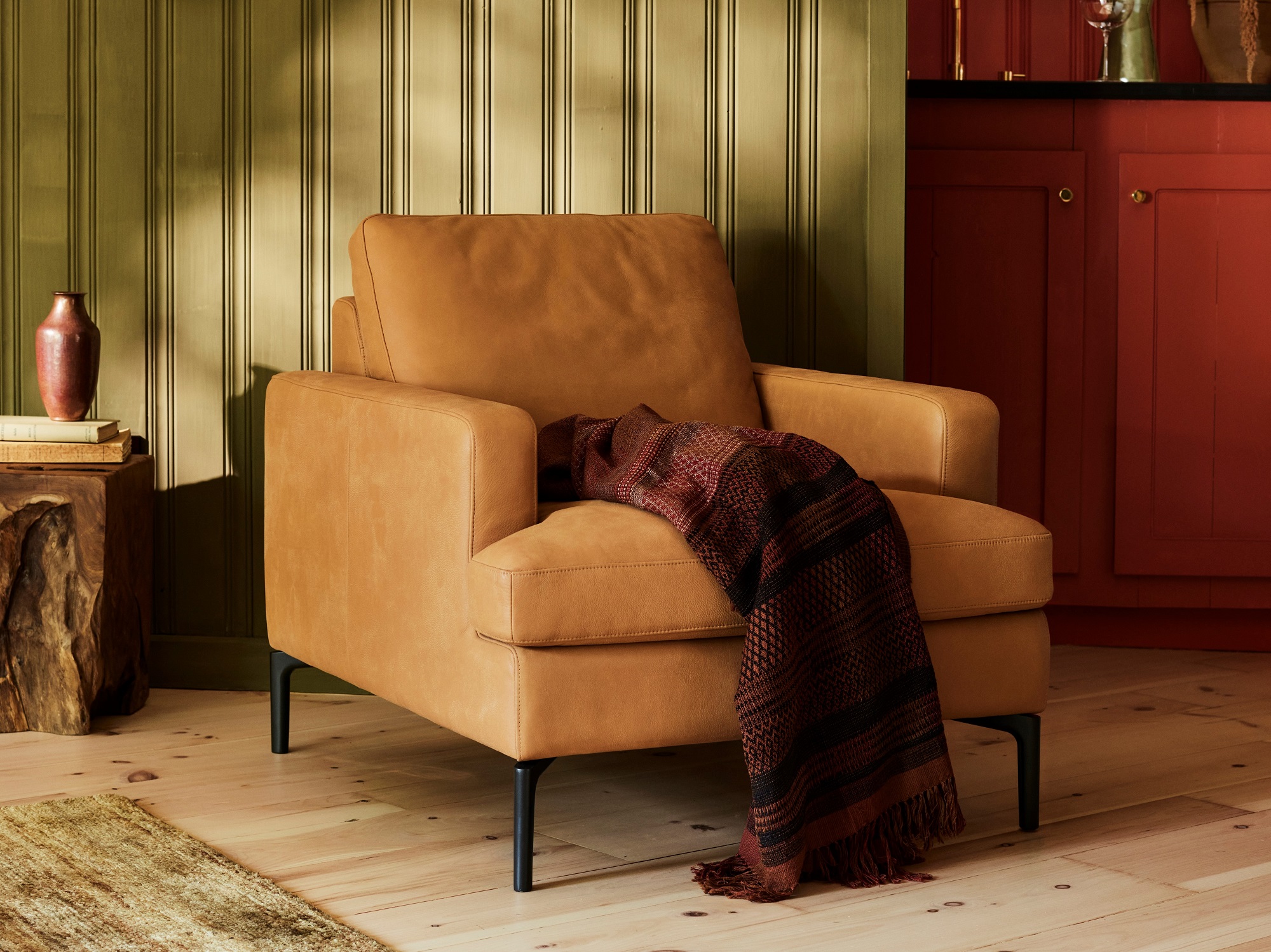 Brown leather armchair with purple throw in mid century living room