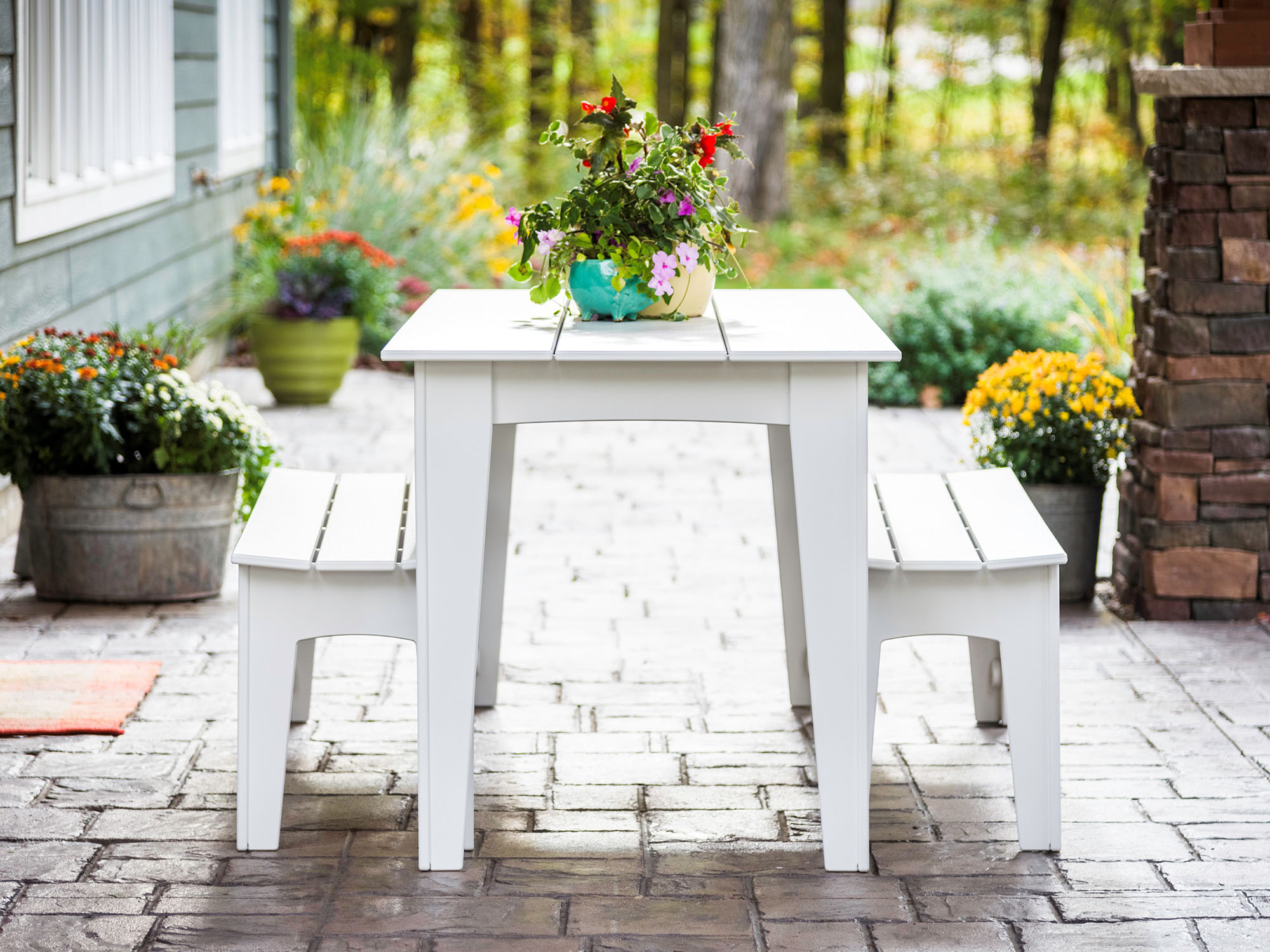 White outdoor dining table with matching benches on patio