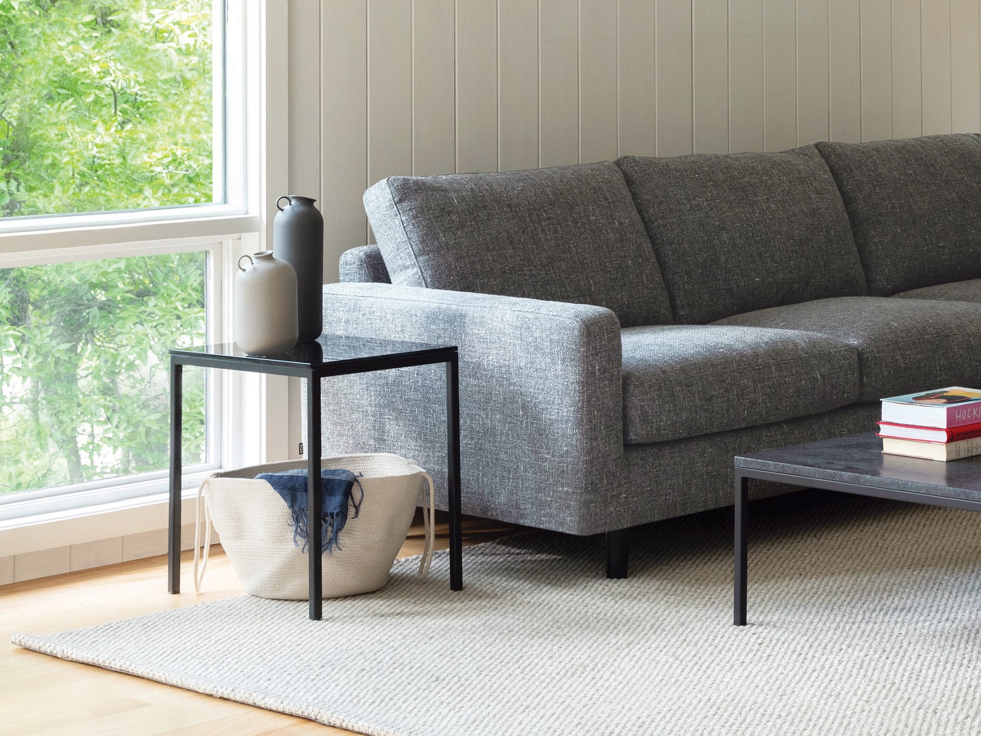 Black marble top end table beside grey sofa in modern living space