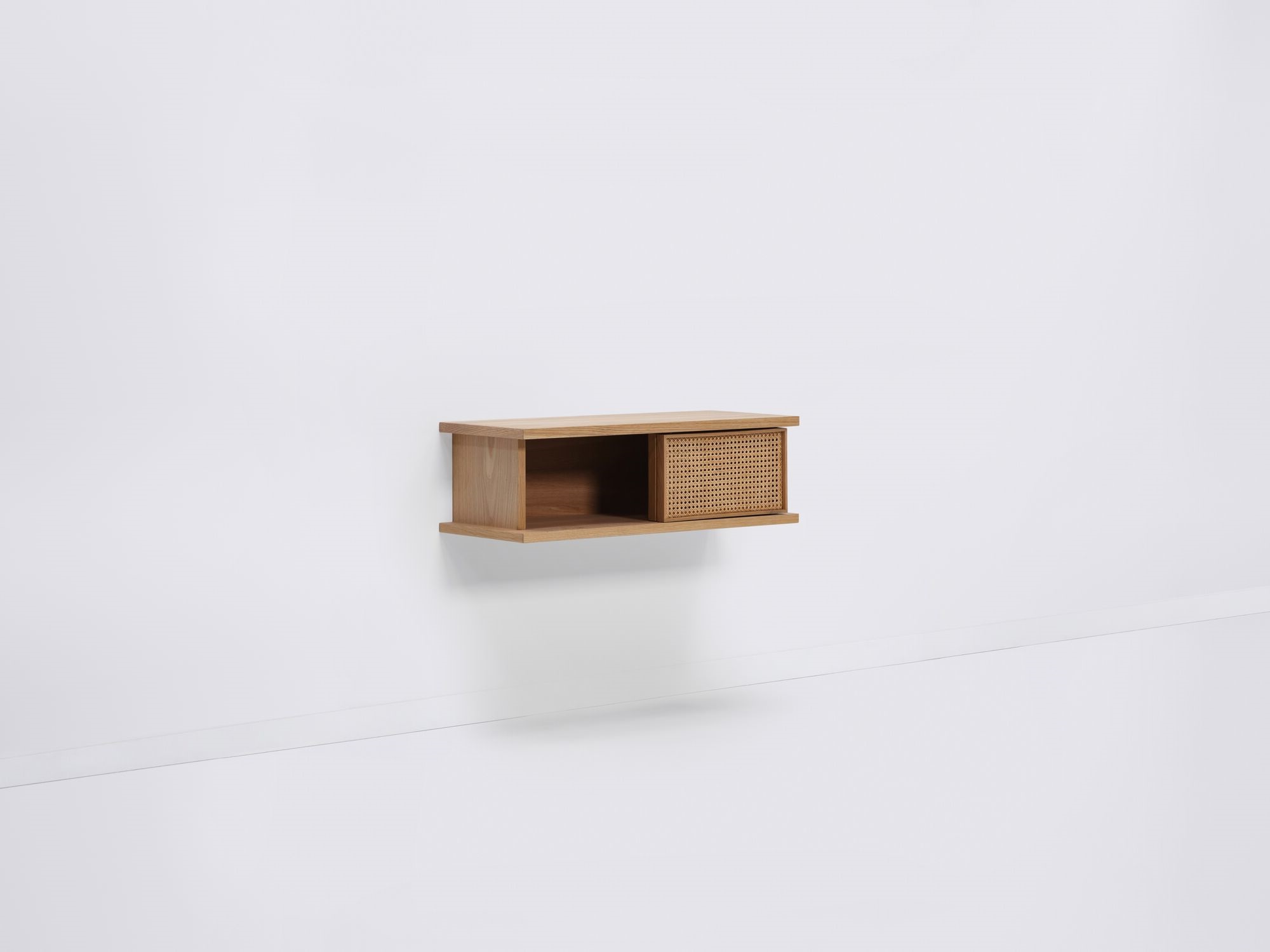 Short oak floating shelf with natural cane doors open front angle view