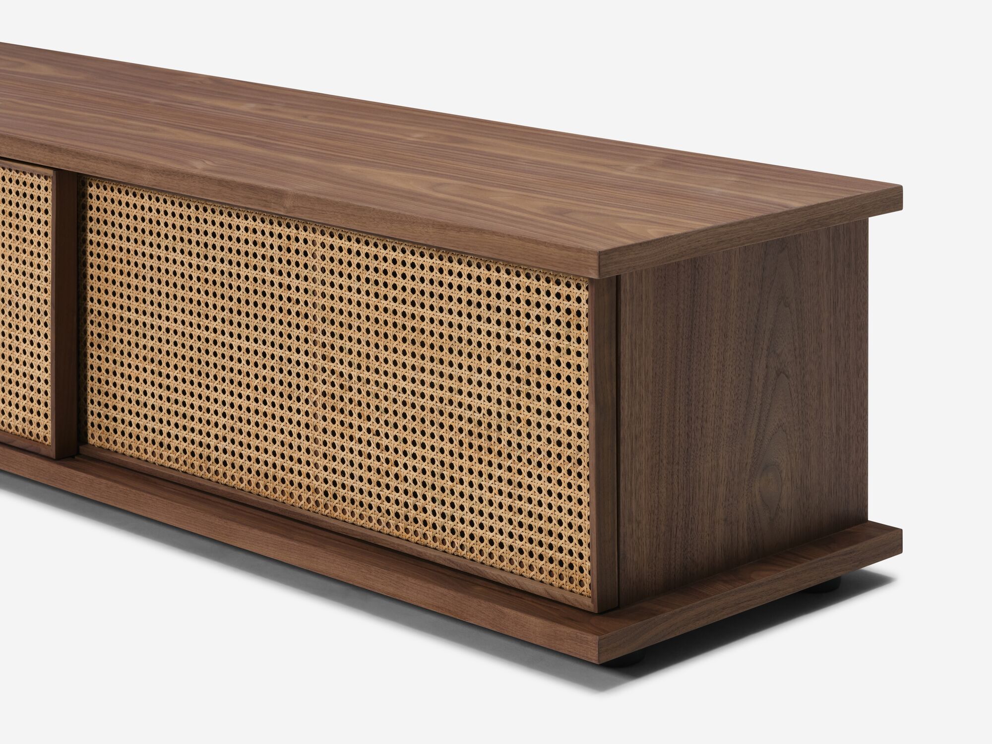 Low walnut media unit with natural cane doors detail view