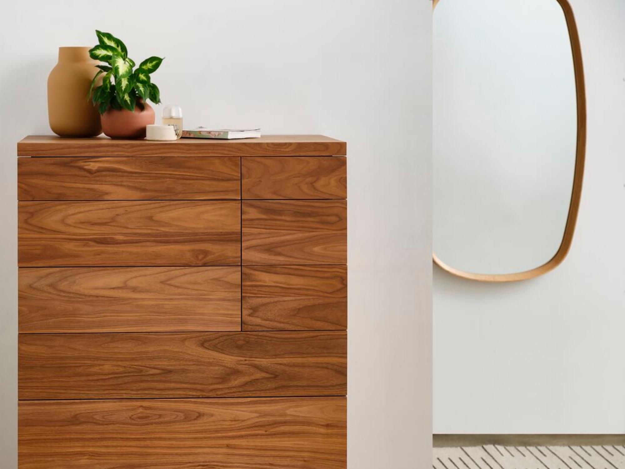 Wood frame oval mirror above runner rug in modern bedroom