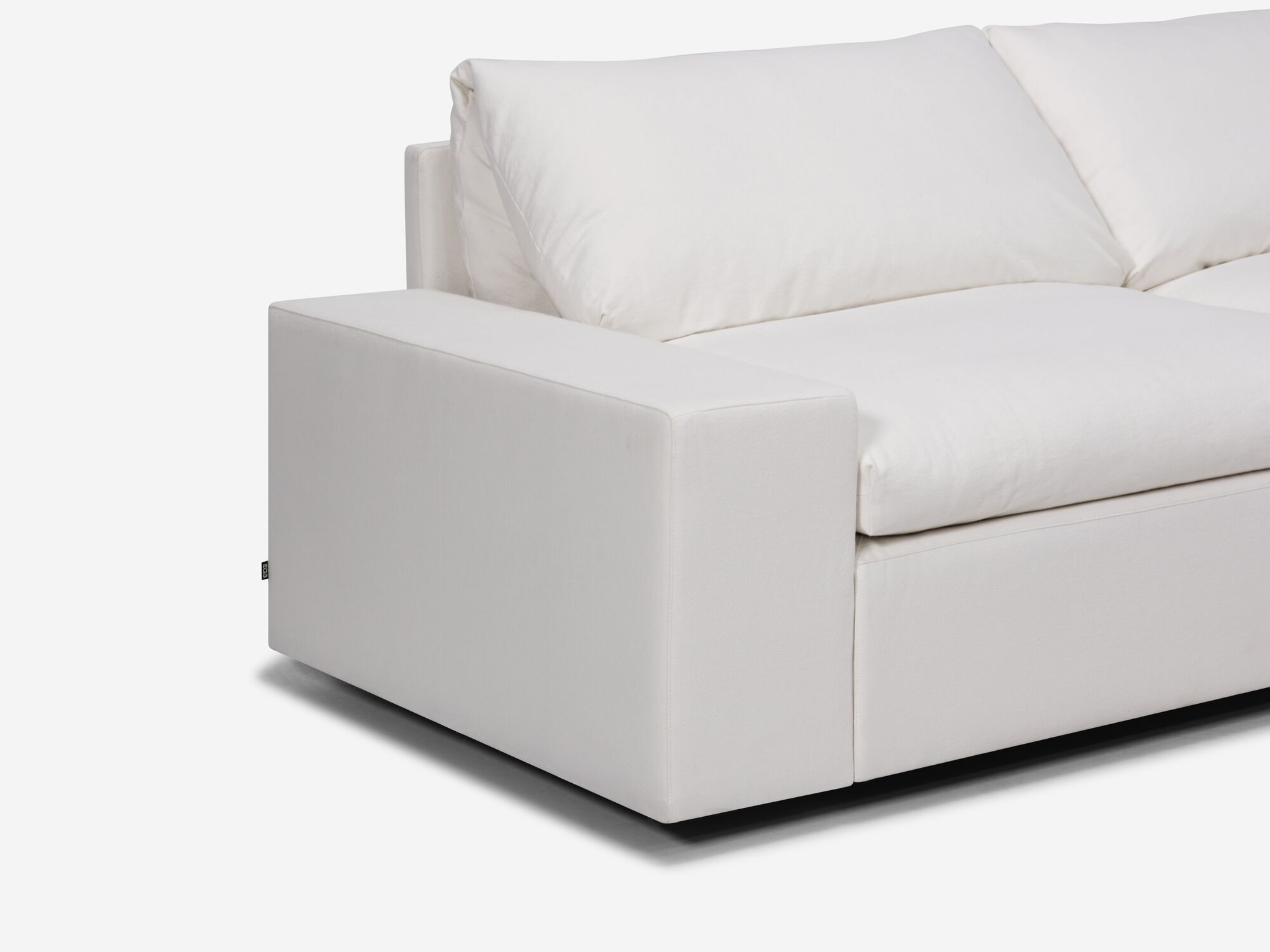 White sectional sofa with right hand chaise and wide arms seat detail view