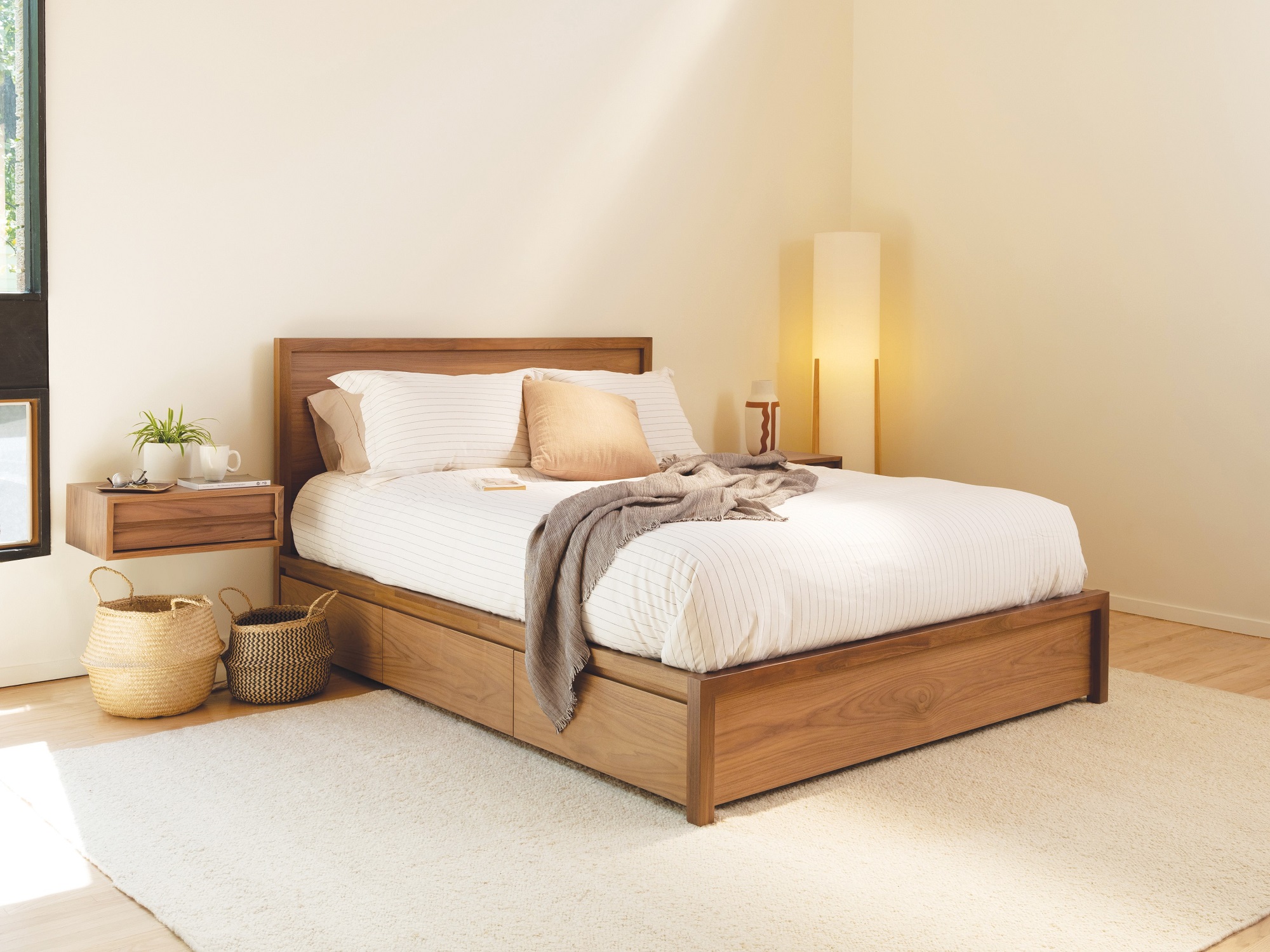 Walnut drawer storage bed with matching floating nightstand in boho bedroom