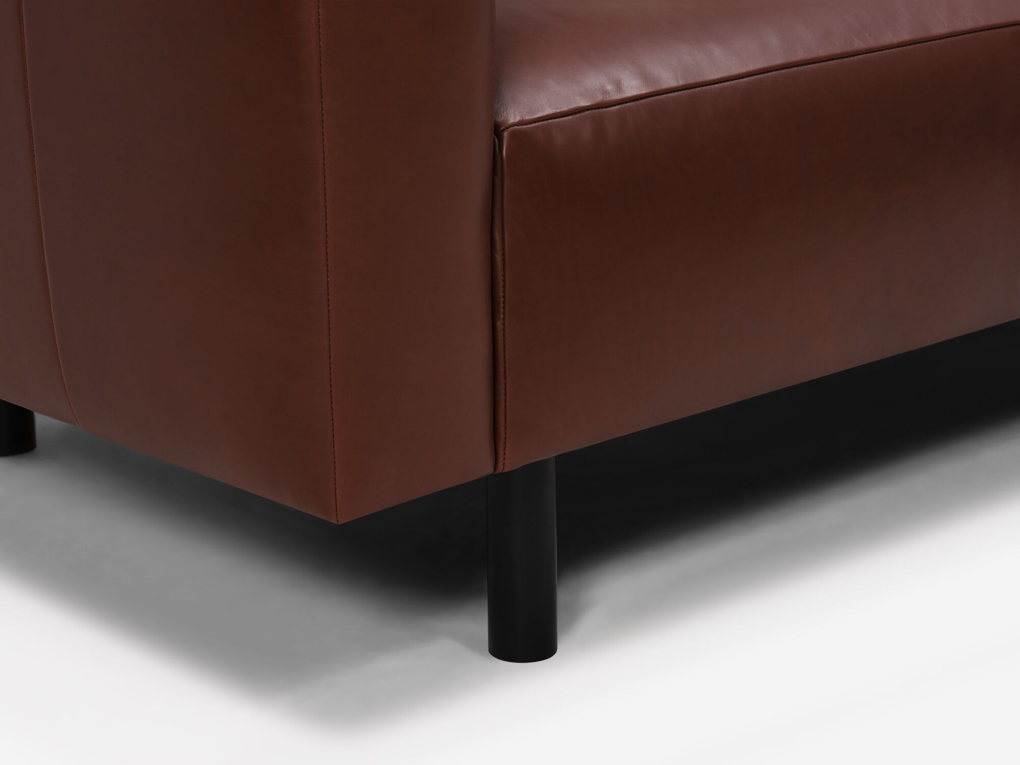 Dark brown leather sofa leg detail view