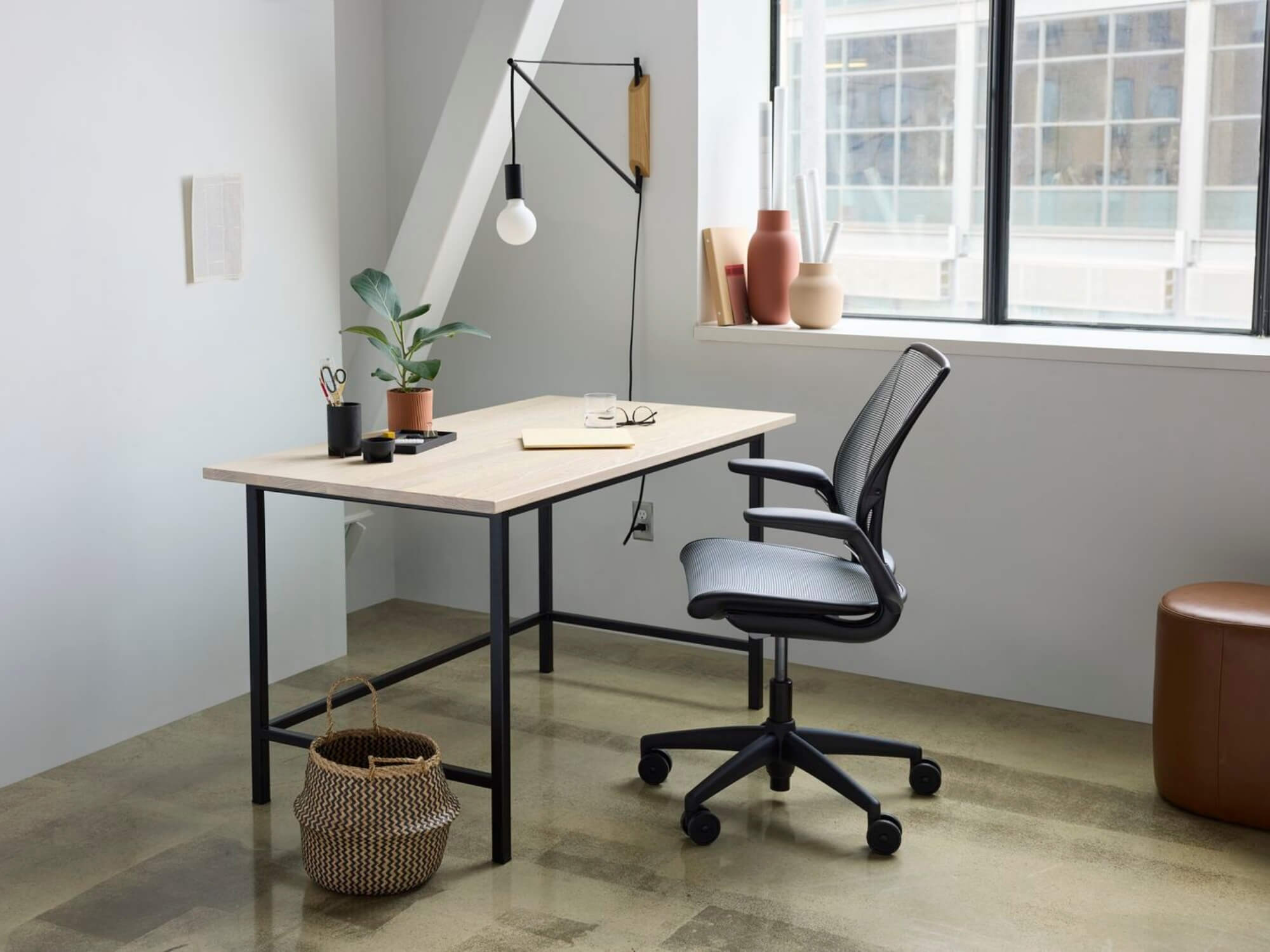 Woven storage basket on floor beside the modern desk