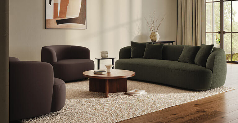 Un grand sofa vert, une table en noyer et deux chaises sont présentés dans un salon moderne. Lien vers la catégorie canapes modulaires