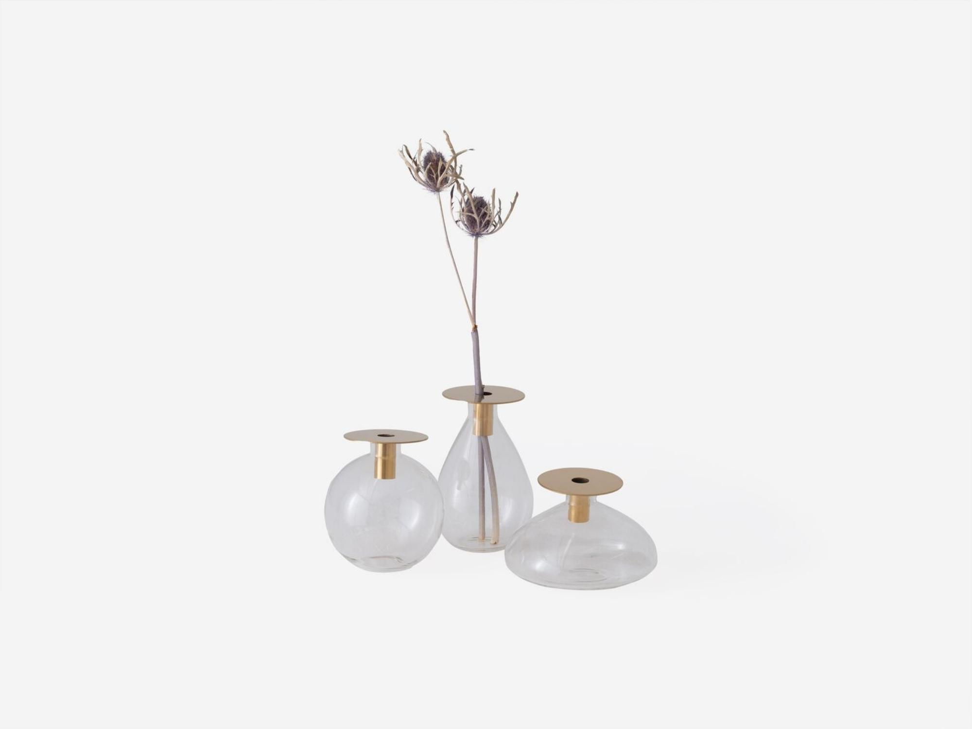 Tall, short, and round glass and gold flower vases on white background