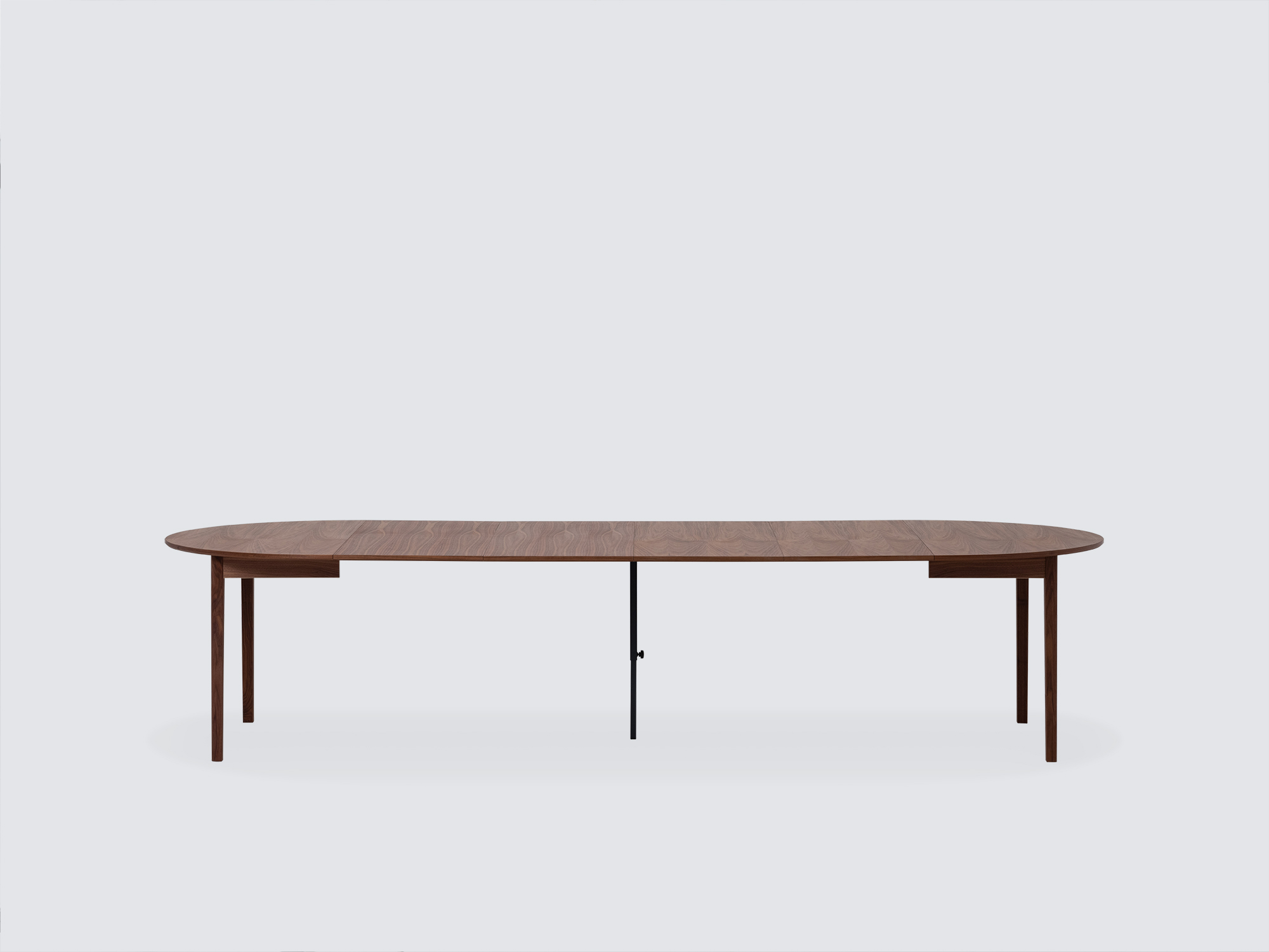 Side view of the large expanded Ease Expandable Dining Table in walnut