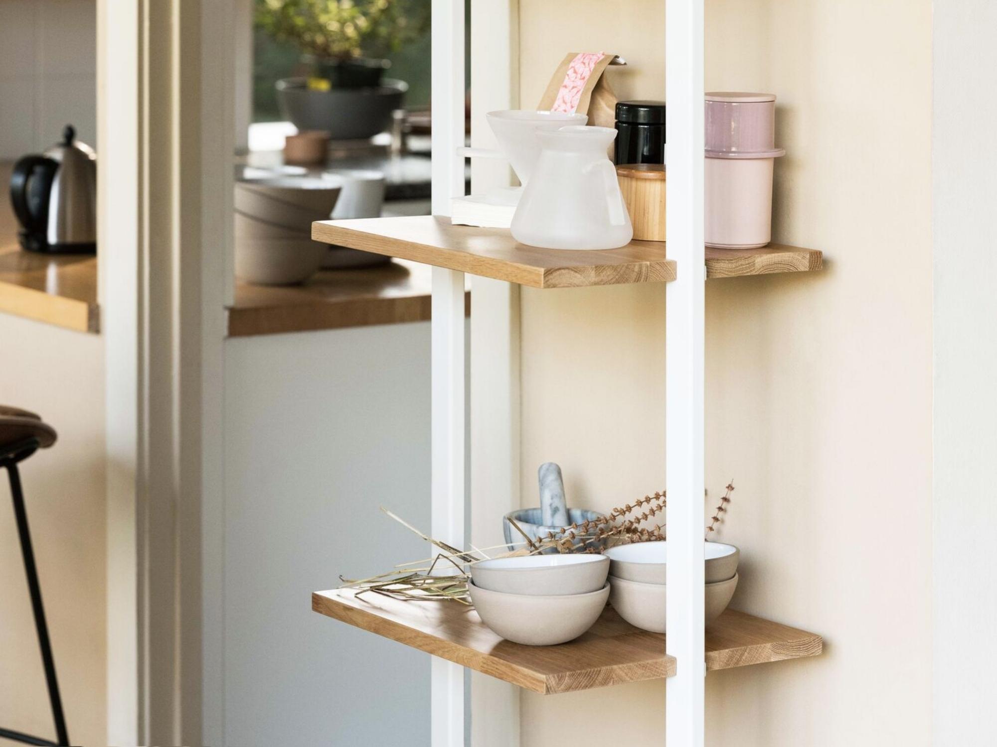 White and oak open shelf storage stacked with dishes and plant pots