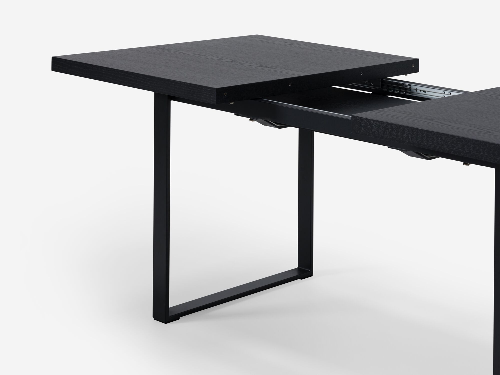 Expandable dining table with black legs and black top detail view