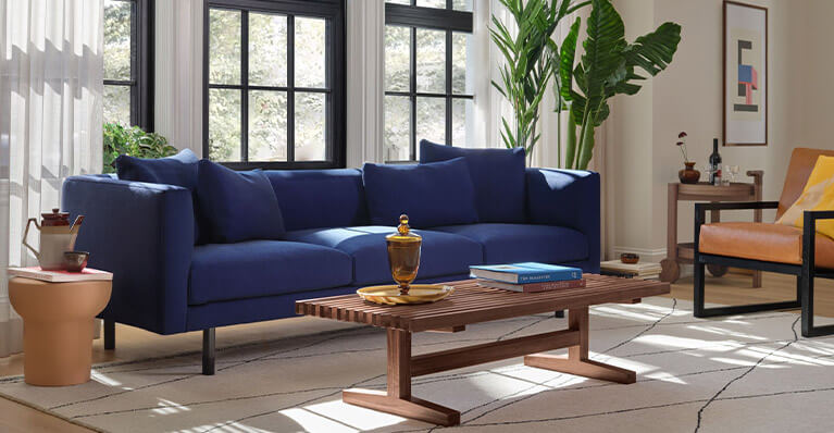 Large blue sofa is displayed in a brightly lit living room. Link to sofas category