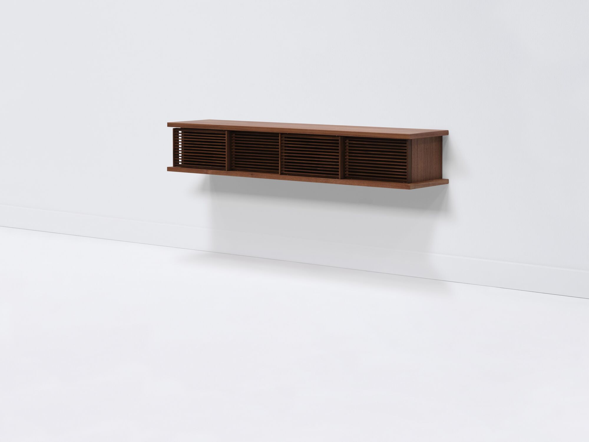 Medium walnut floating media unit with slatted doors front angle view