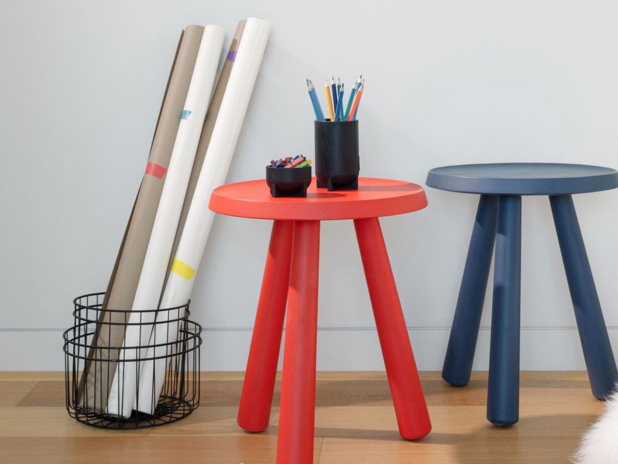 Black wire storage baskets are stacked and hold art supplies