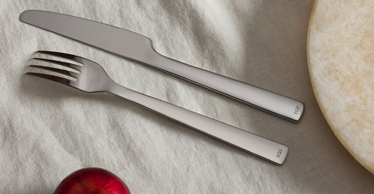 Stainless steel EQ3 branded flatware is shown in close detail. Link to promotion page