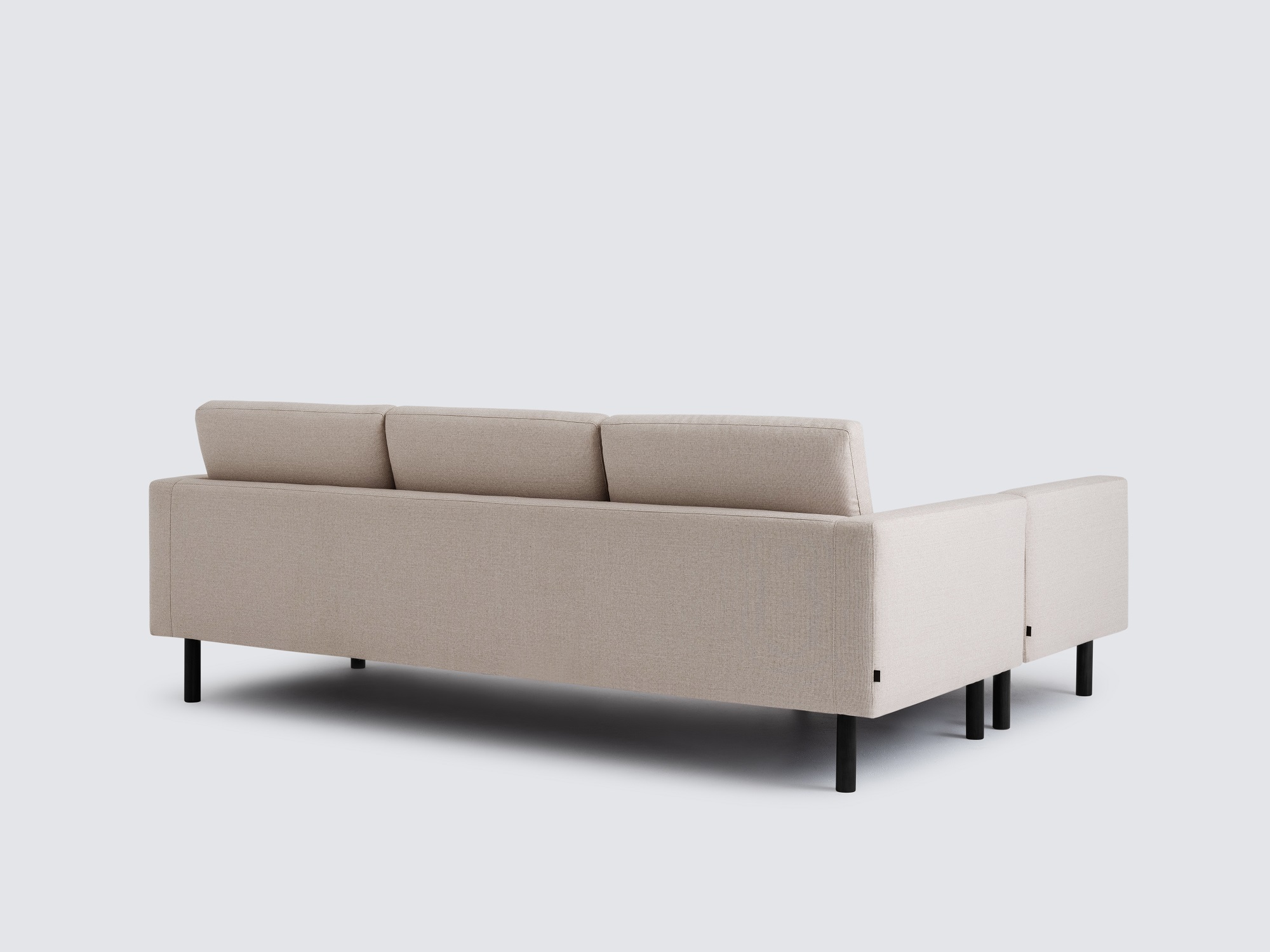 Back angled view of the Joan right hand sectional upholstered in beige fabric