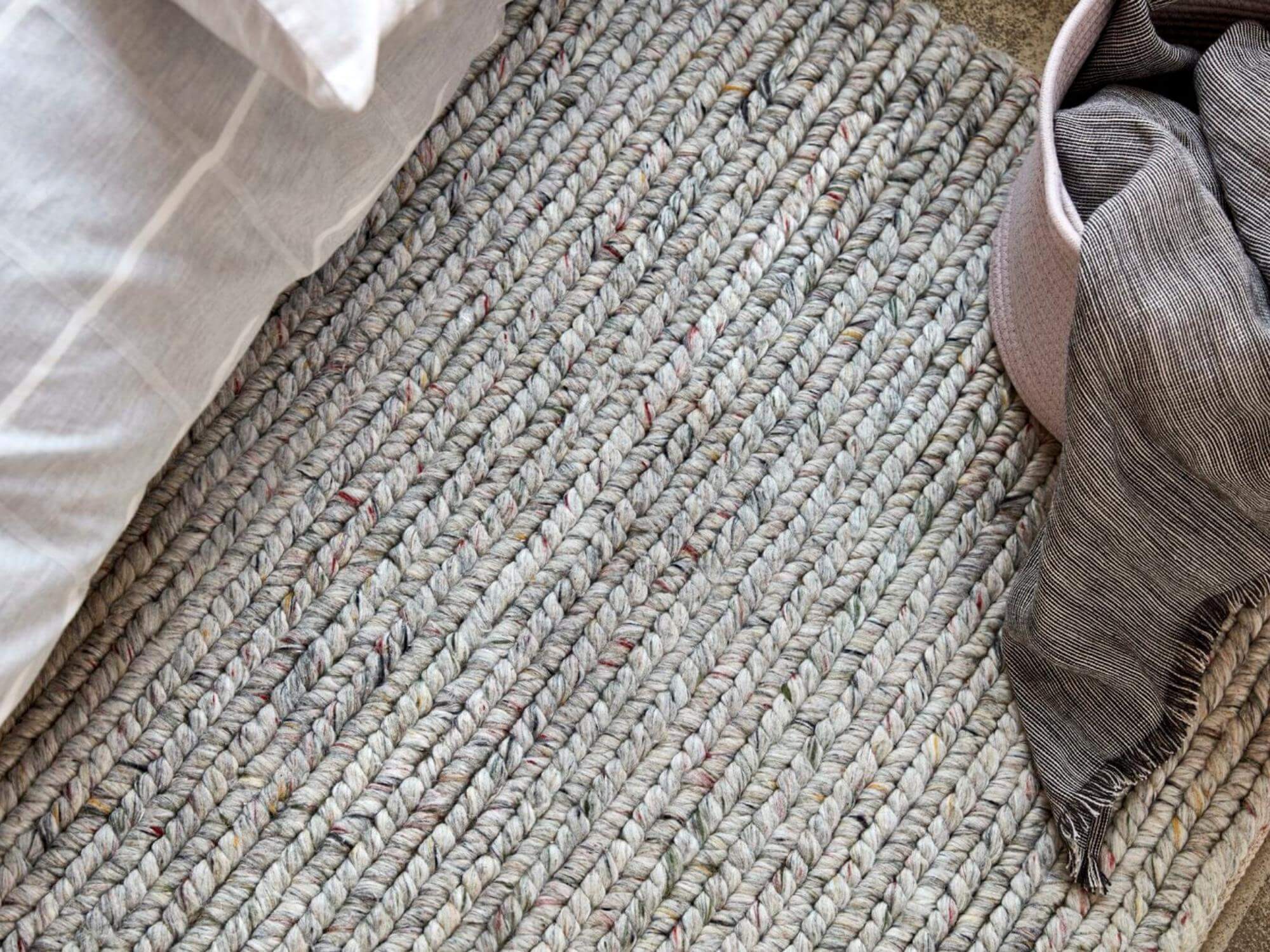 Grey braided rug with throw blanket in basket and duvet cover set