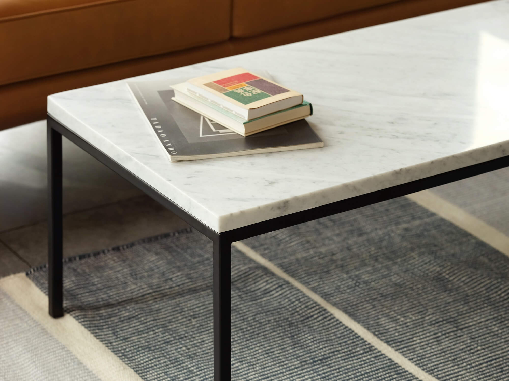 Rectangular white marble coffee table with grey rug underneath