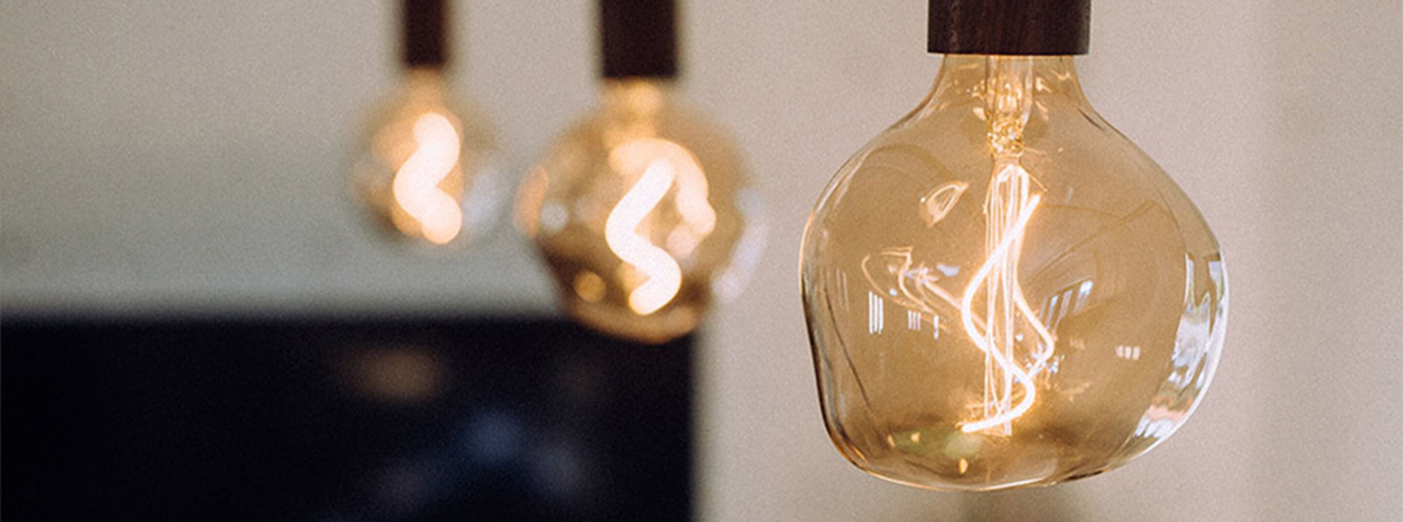 Three small edison style bulbs are displayed in detail hanging and lit. Link to Tala brand category