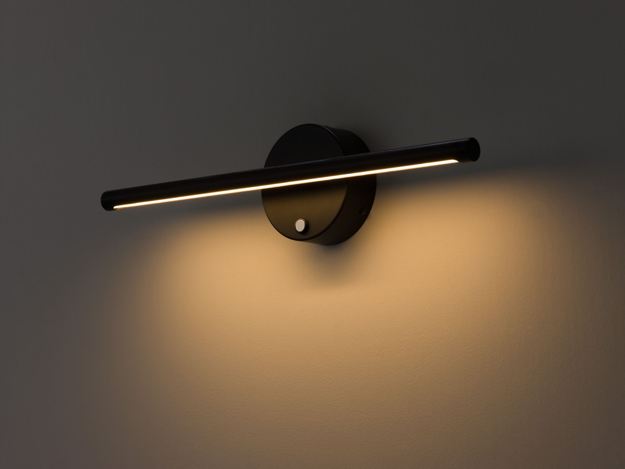 Vertical black slim wall lamp with light on detail view