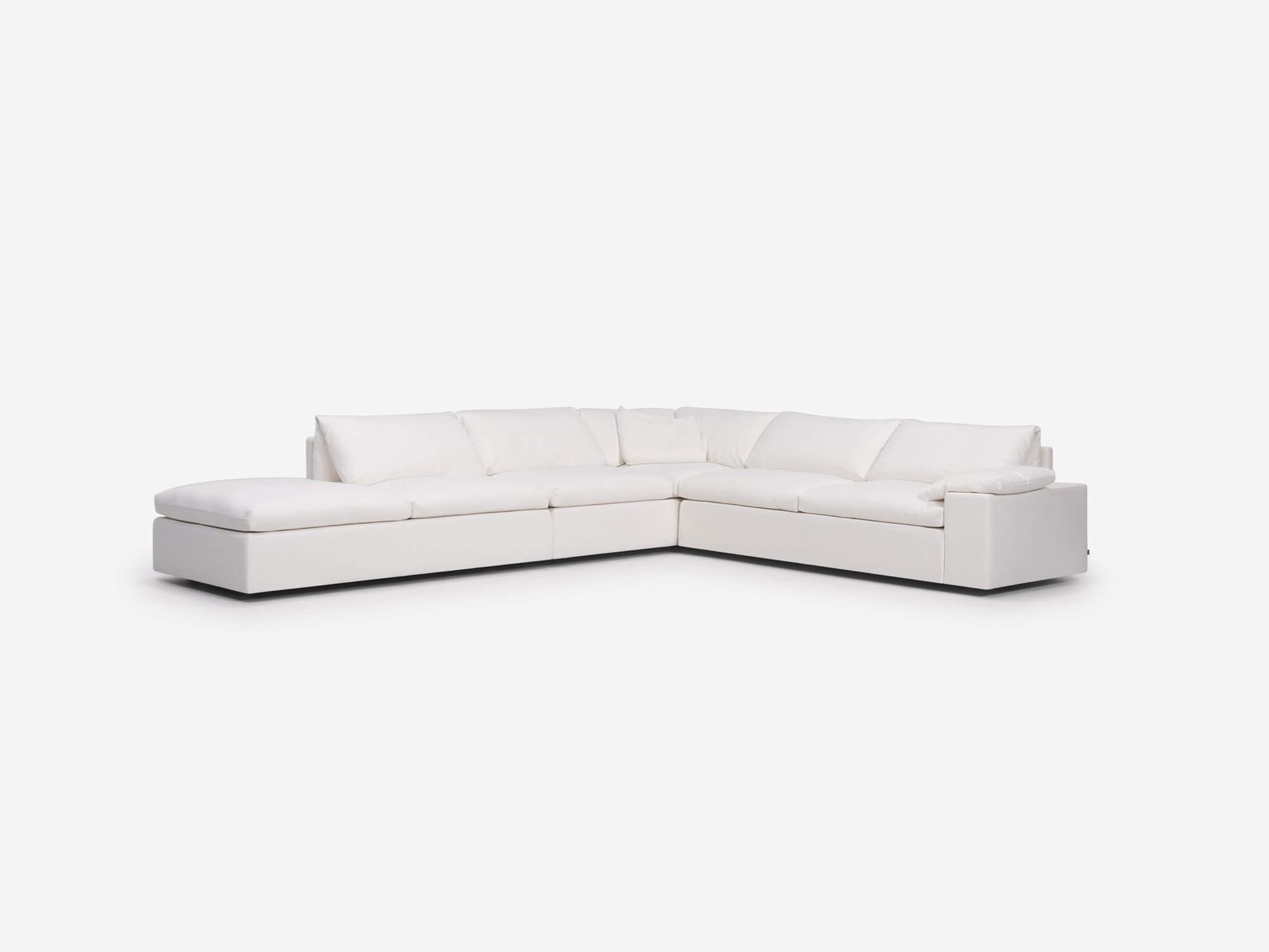Left angle view of white sectional sofa with left hand chaise, pillow and wide arms