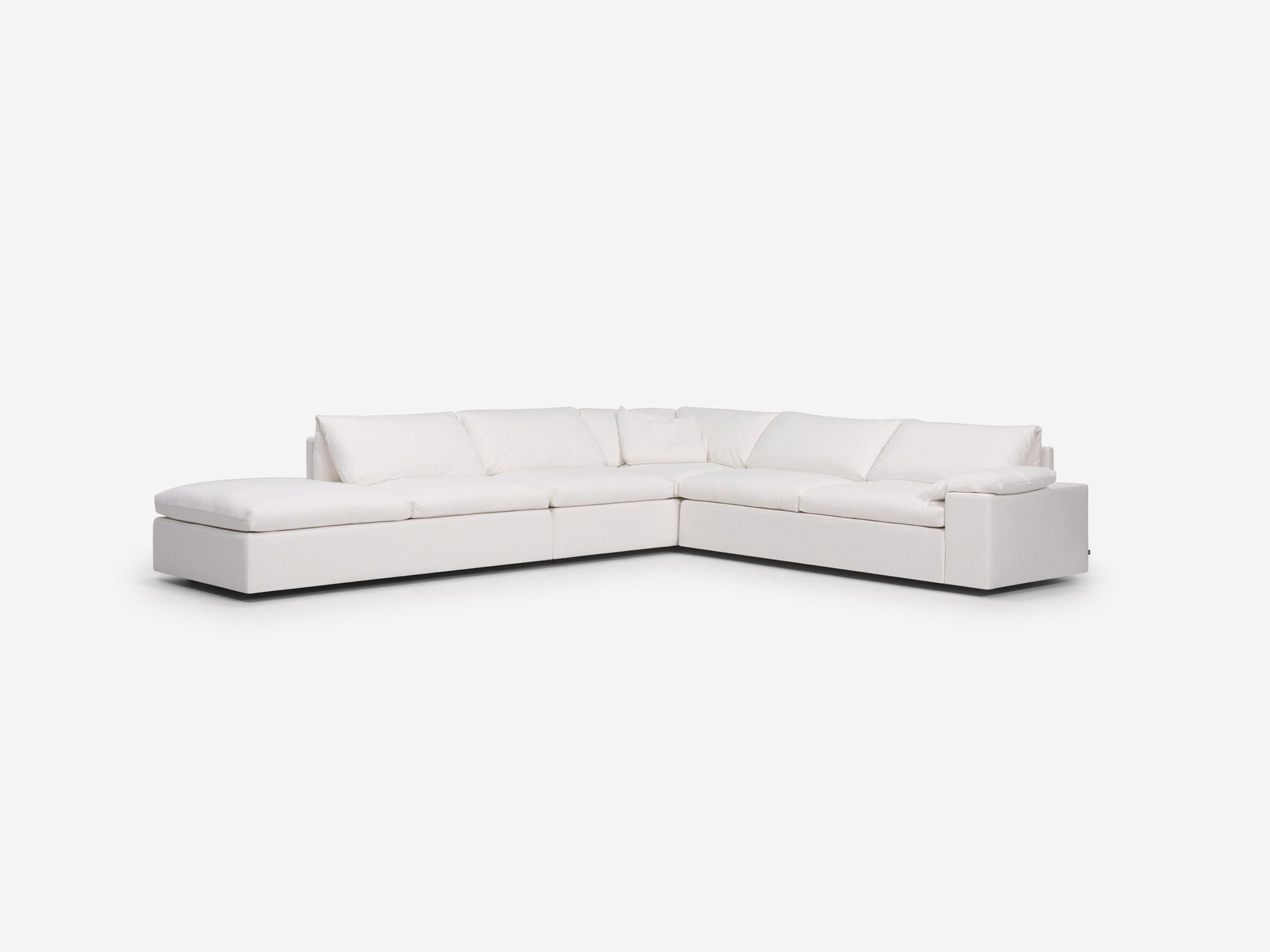 Left angle view of white sectional sofa with left hand chaise, pillow and wide arms