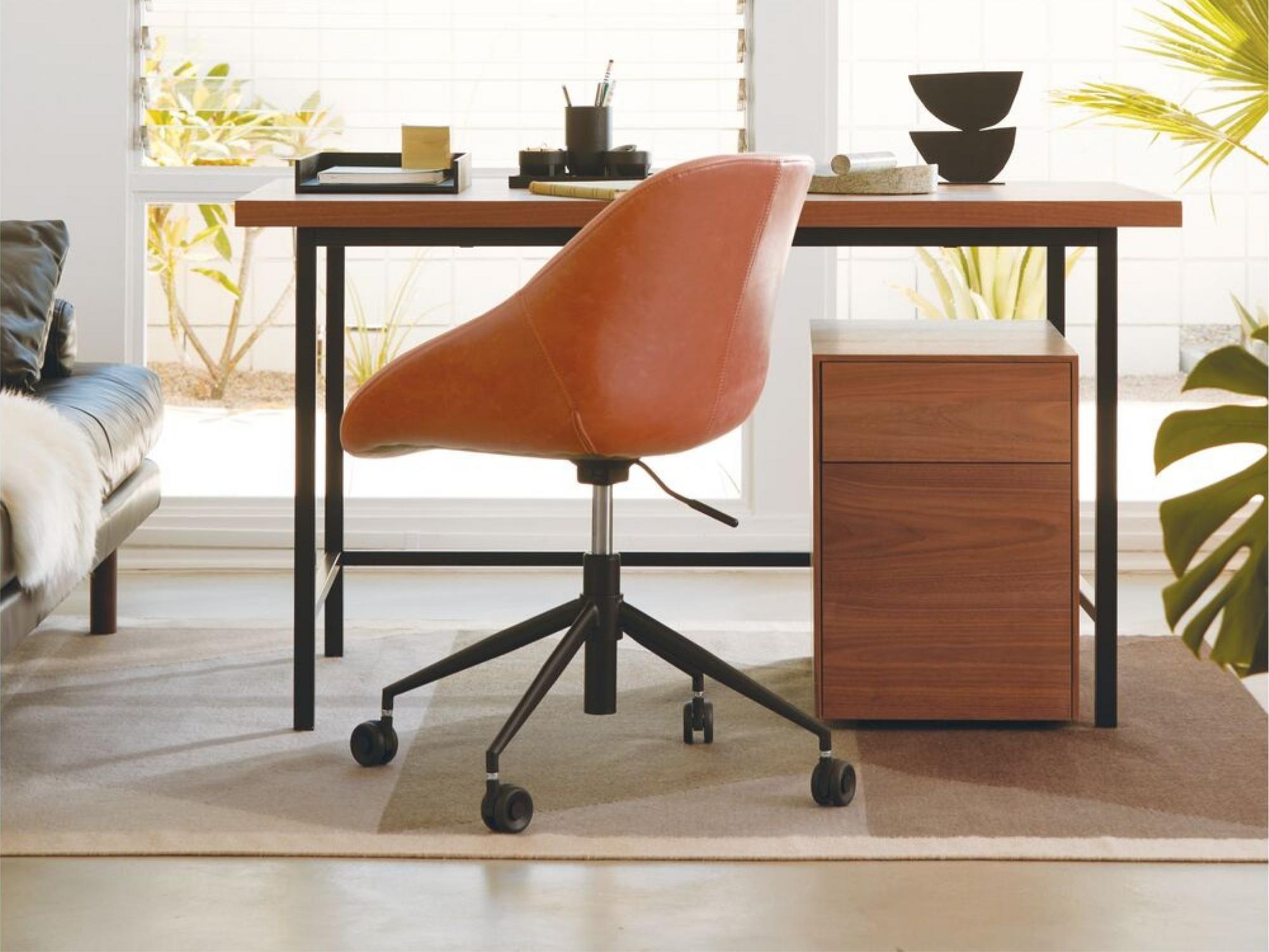 Area rug under oak office table and brown leather chair