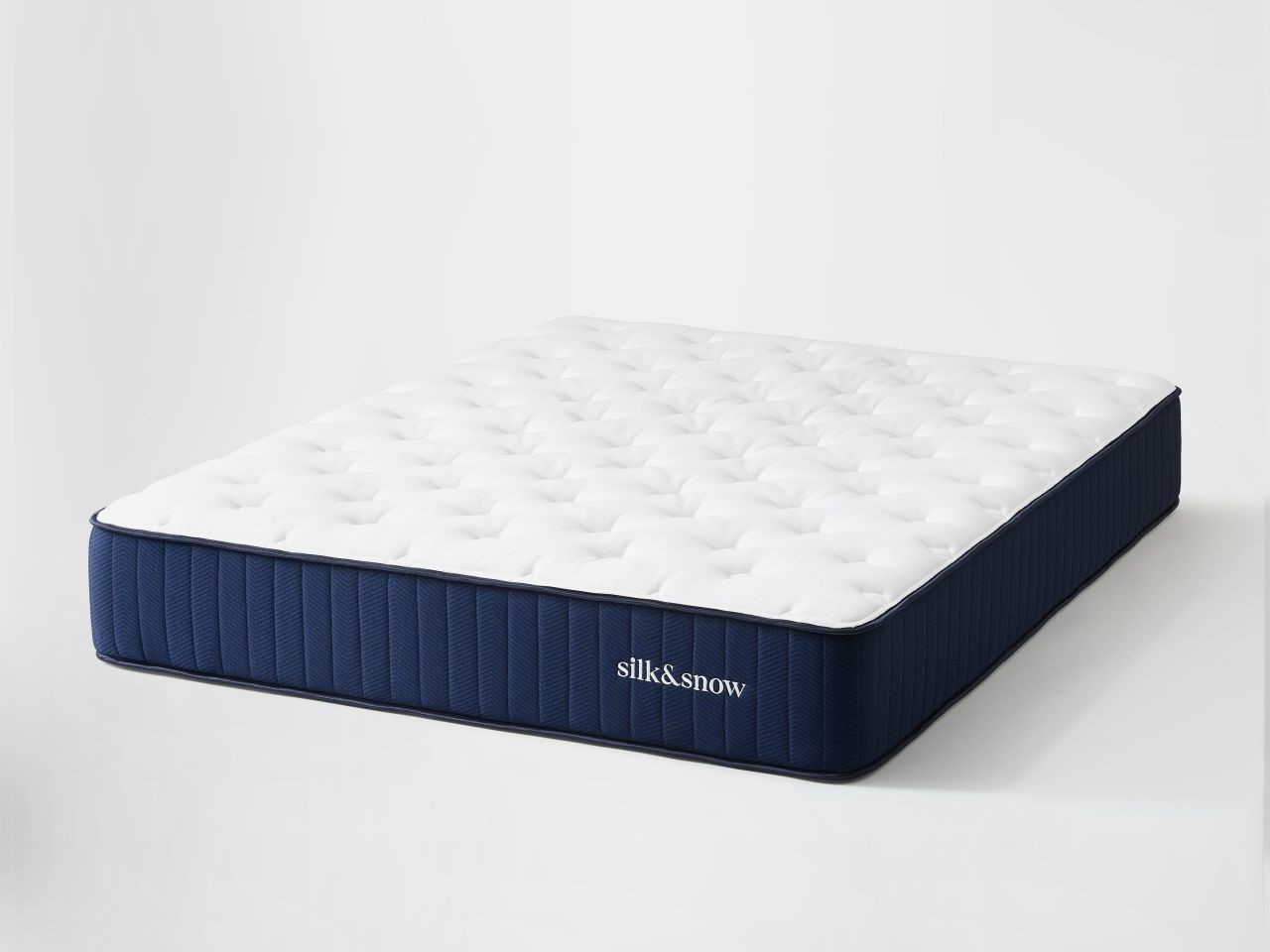 Hybrid firm mattress with blue sides and white top angled view