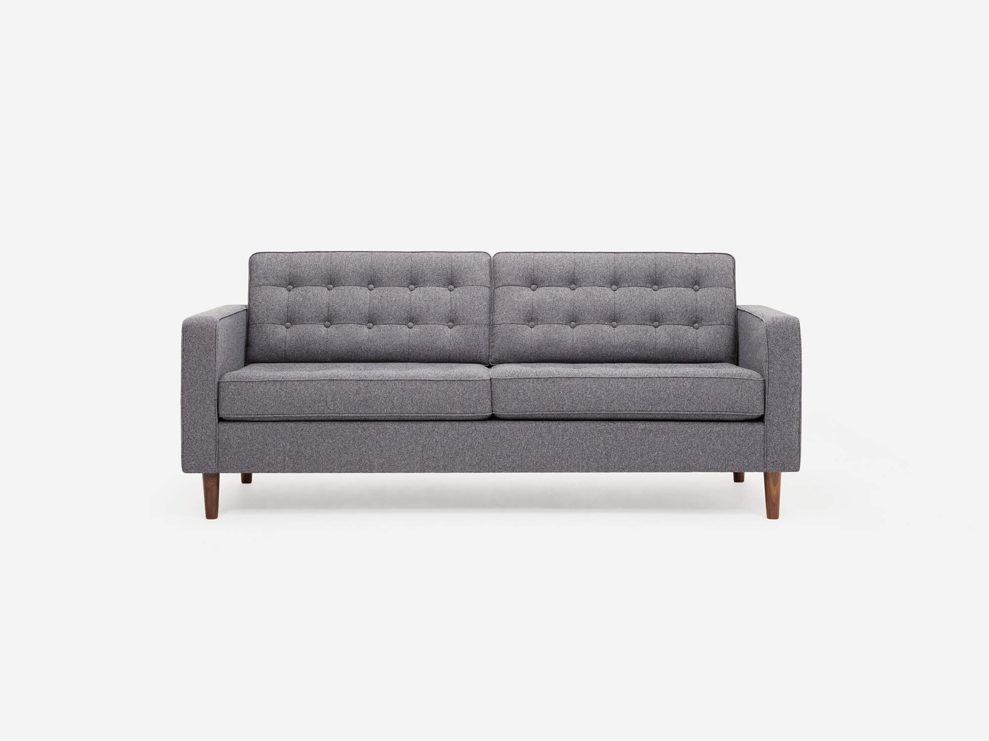 Front view of grey tufted apartment couch with walnut legs