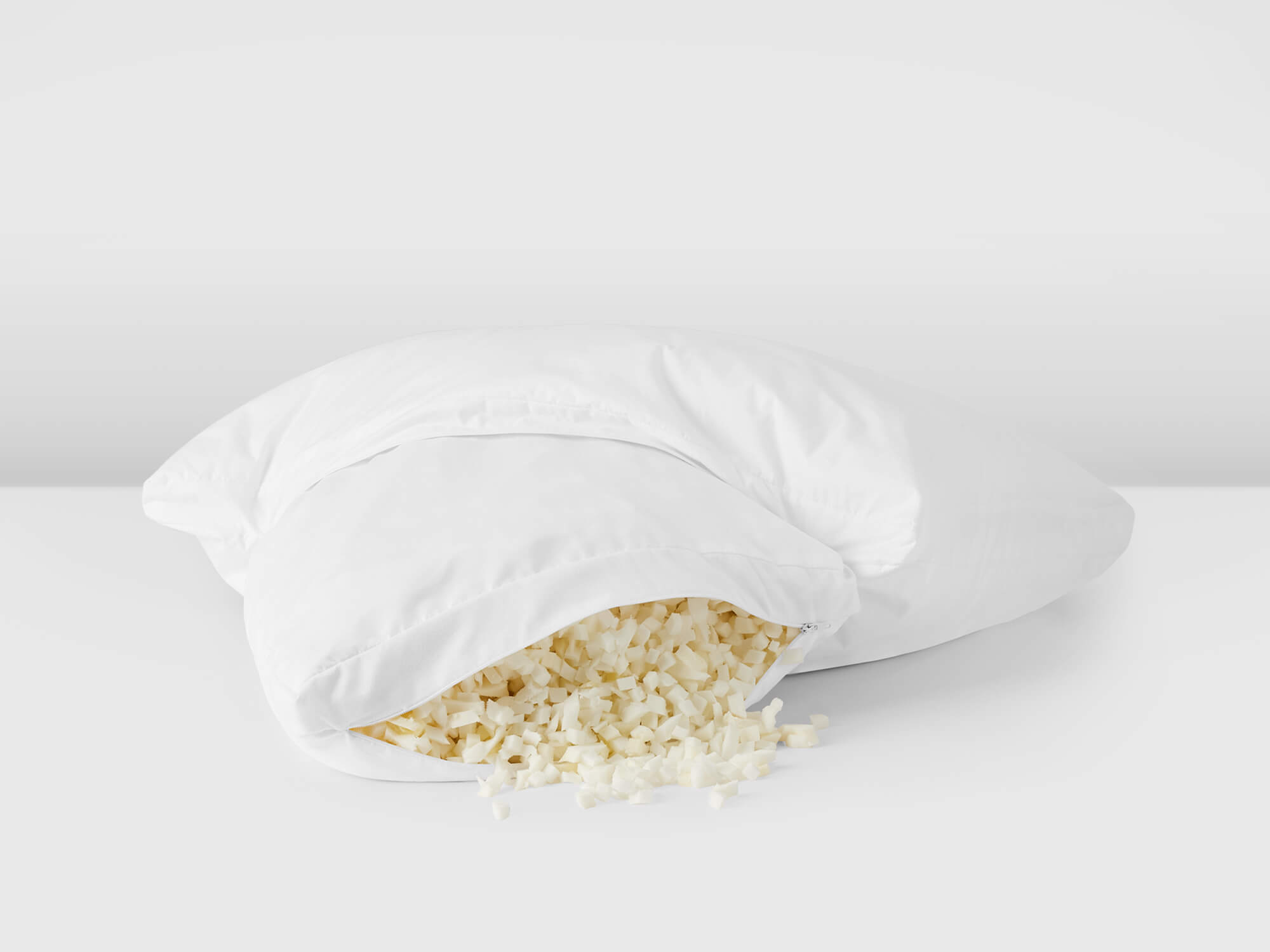 White pillow with filling spilling out side view