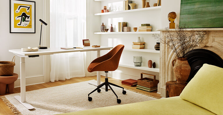White office desk is shown in a home office setting with a fabric orange chair. Link to office category