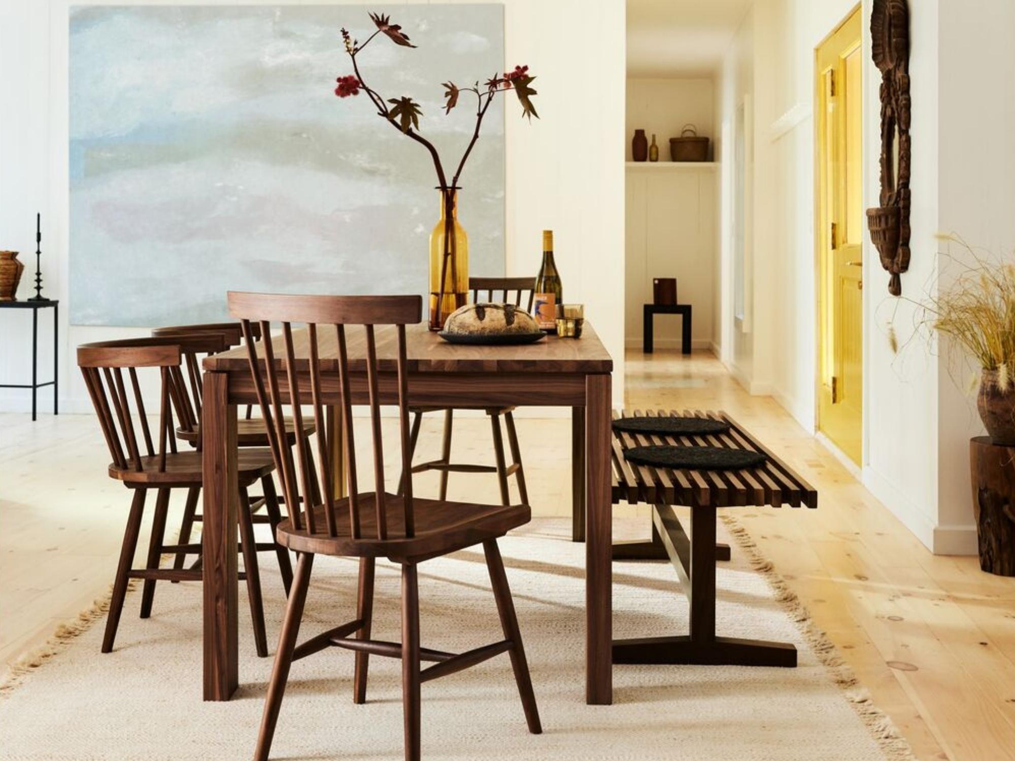 Slatted oak bench with tray on it next to modern dining table set