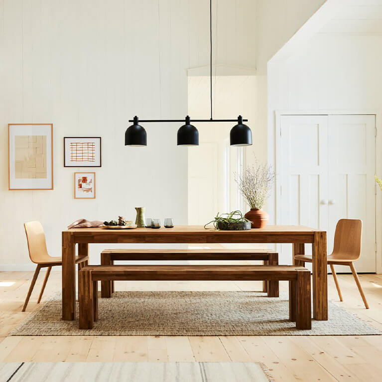 Oak dining table and matching bench is shown in a dining room setting. Link to dining category