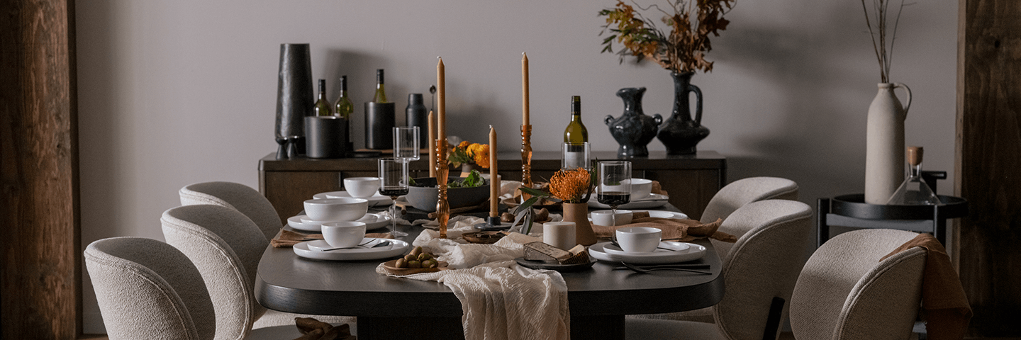 Glassware and dishware arranged on a beige tablecloth
