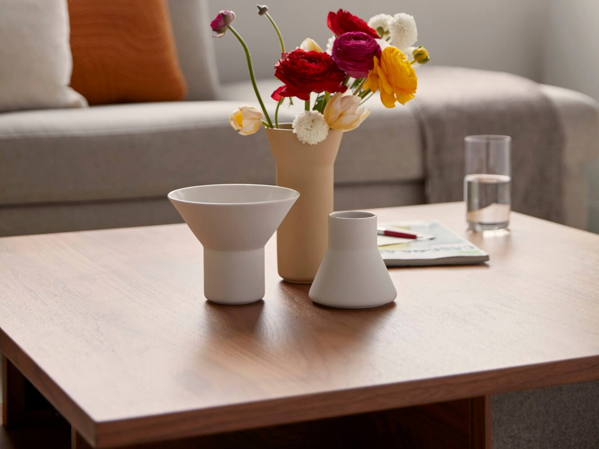 Three clay flower vases on an oak coffee table in living space